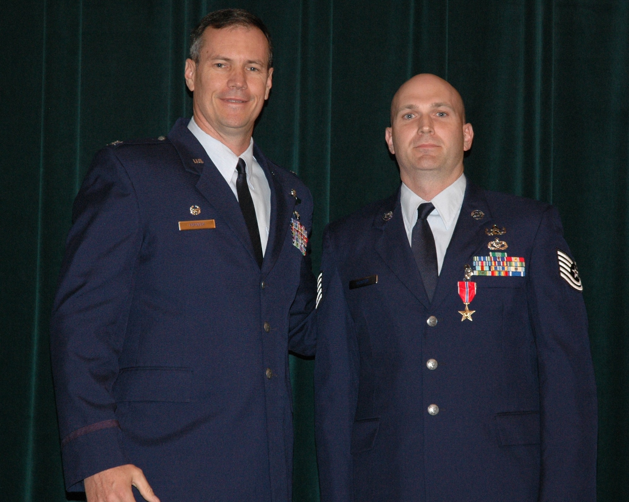 Col. Michael Popovich, 944th Fighter Wing commander, presents Tech. Sgt. Stephen Hunter, 944th Civil Engineer Squadron Explosive Ordnance Disposal technician, with the Bronze Star during commander's call June 6. (U.S. Air Force photo/Tech. Sgt. Susan Stout)