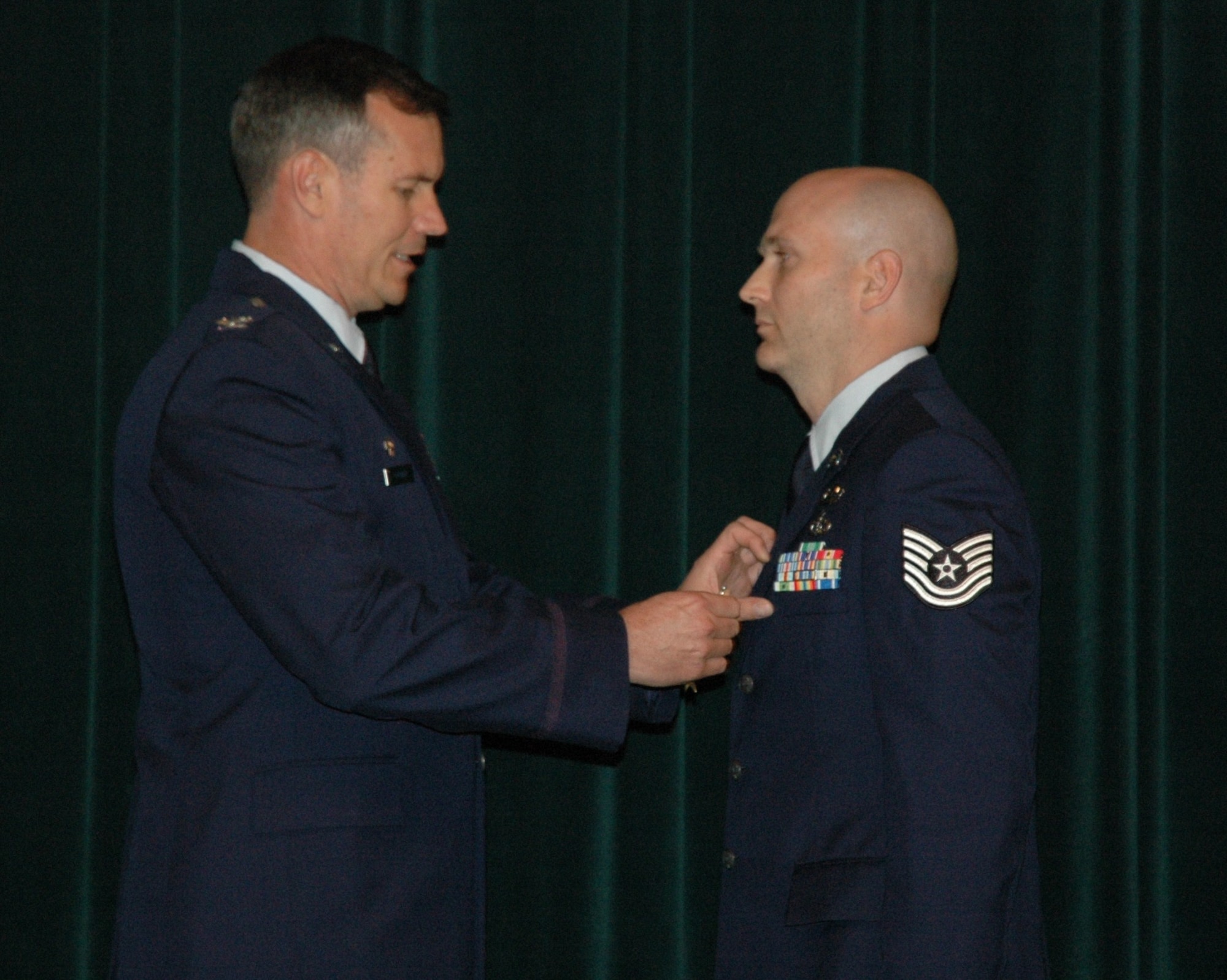 Col. Michael Popovich, 944th Fighter Wing commander, presents Tech. Sgt. Stephen Hunter, 944th Civil Engineer Squadron Explosive Ordnance Disposal technician, with the Bronze Star during commander's call June 6. (U.S. Air Force photo/Tech. Sgt. Susan Stout)