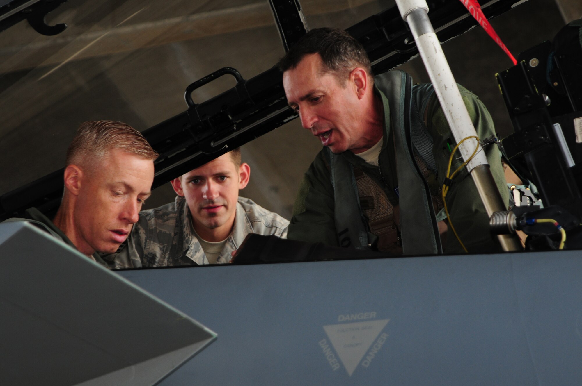 18th Wing Commander Brig. Gen. Brett Williams assists Command Chief Master Sgt. Michael Warner before his F-15 familiarization flight as Senior Airman Stanley Weaver, a Crew Chief from the 18th Aircraft Maintenance Squadron, ensures everything is properly secured, May 27. (U.S. Air Force photo/Staff Sgt. Lakisha Croley)