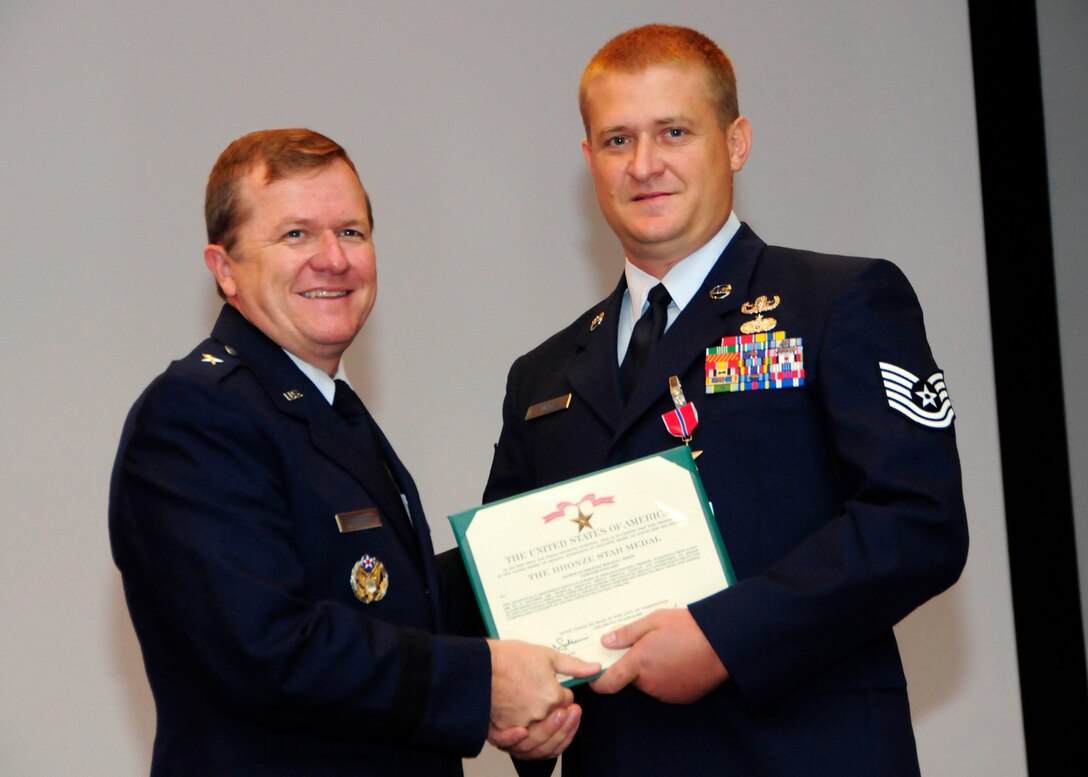 ANDERSEN AIR FORCE BASE, Guam - Tech. Sgt. Ronald White, 36th CES explosive ordnance disposal flight team leader, receives a Bronze Star medal from Brig. Gen. Ruhlman during the May promotion ceremony here May 29. Sergeant White and his team were responsible handling many different categories of explosives in a combat environment, including finding and disarming improvised explosive devices and unexploded ordnances and cataloguing and tracking weapons found in weapons caches.  The Bronze Star is awarded to members of all branches of military service and may be awarded either for combat heroism or for meritorious service. (U.S. Air Force photo by Airman 1st Class Courtney Witt)