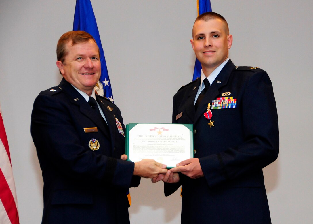 ANDERSEN AIR FORCE BASE, Guam - Capt. Raymond Kerr, 36th CES chief of construction management, receives a Bronze Star medal from Brig. Gen. Ruhlman during the May promotion ceremony here May 29. Captain Kerr and his joint-deployed team of more than 15 members took on the task of constructing the Afghan National Army’s and Afghan National Fleet’s facilities, including their bases and police stations. These facilities allowed the ability to bed down more than 700 Afghan forces. The Bronze Star Medal is awarded to members of all branches of military service and may be awarded either for combat heroism or for meritorious service. (U.S. Air Force photo by Airman 1st Class Courtney Witt)