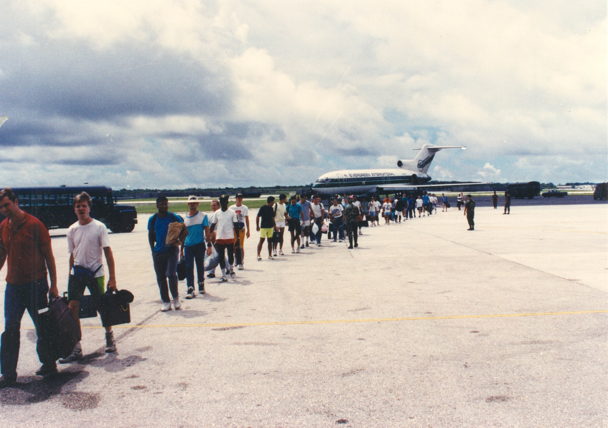 ANDERSEN AIR FORCE BASE, Guam - Refugees stream from chartered aircraft after evacuating Clark Air Base, Philippines, June 1991.  More than 21,000 refugees were flown to Andersen in less than one week.  The Military Airlift Command alone airlifted 15,000 passengers on 246 missions; the others came in on chartered flights.
(Courtesy photo).
