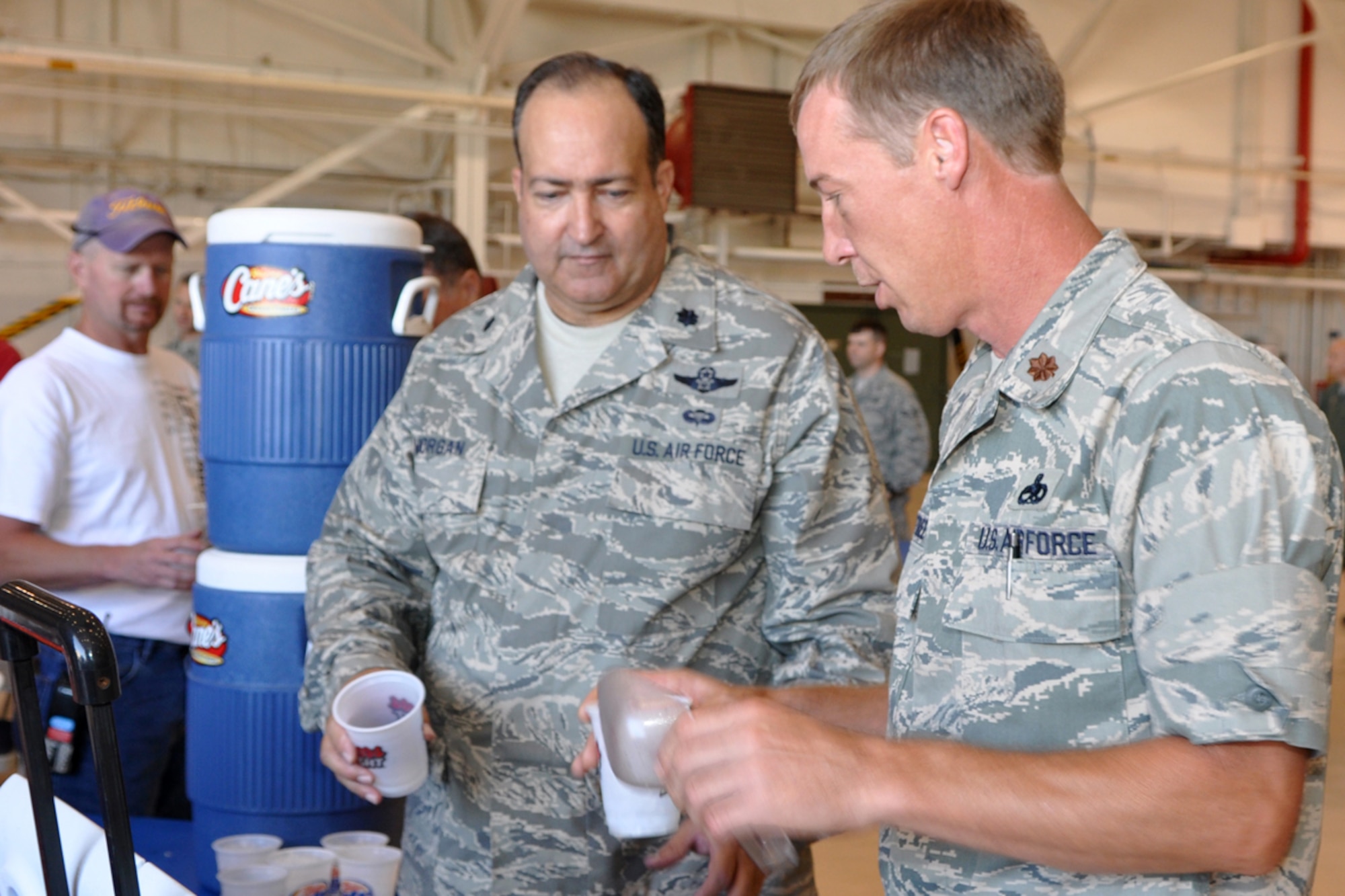 Lt. Col. Charlie Morgan, 917th Wing, process manager, and Maj. Warren Crabtree, 917 Maintenance Operations Squadron, commander, serve tea to 917th Wing Airmen during lunch in the A-10 Hangar June 5, 2009, at Barksdale Air Force Base, La. Several Raising Cane’s Chicken Finger restaurants in the Shreveport-Bossier area provided lunch for the Airmen in an effort to “do their part in supporting local men and women who serve our country every day.” (U.S. Air Force photo/Tech. Sgt. Jeff Walston) 