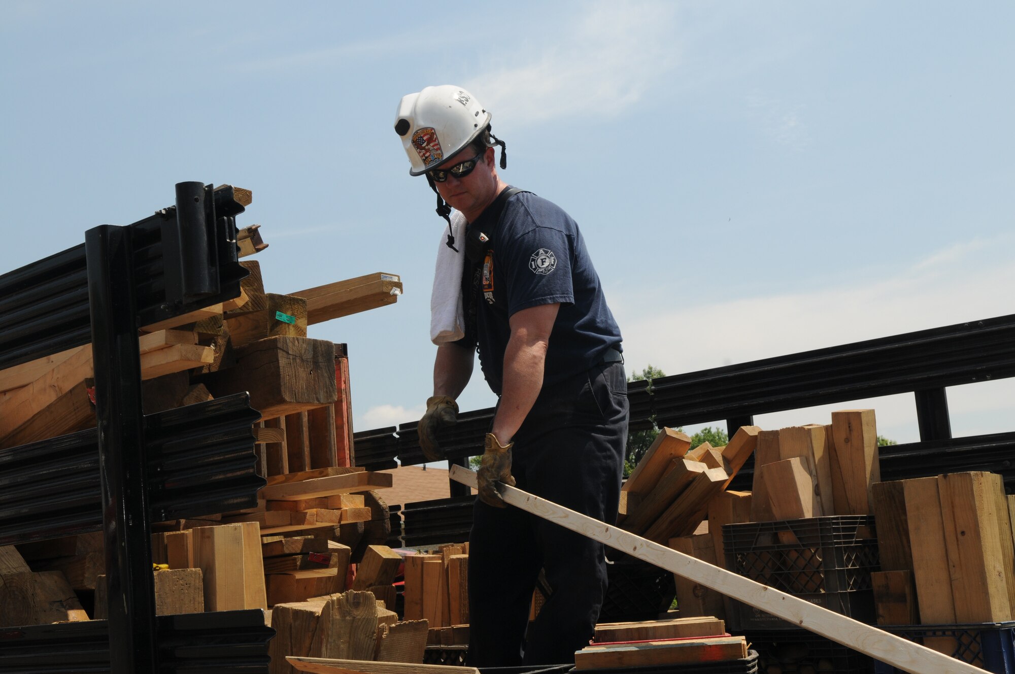 J.C. Carroll, District of Columbia Fire Department Rescue Squad 3, supplies wood for slope shores to support the collapsed floor during a collapse-and-rescue exercise June 8 on Bolling Air Force Base. The coming demolition of Hickam Village housing created a prime location and opportunity June 1 - 12 for the joint training effort. (U.S. Air Force photo by Senior Airman Marleah Miller)