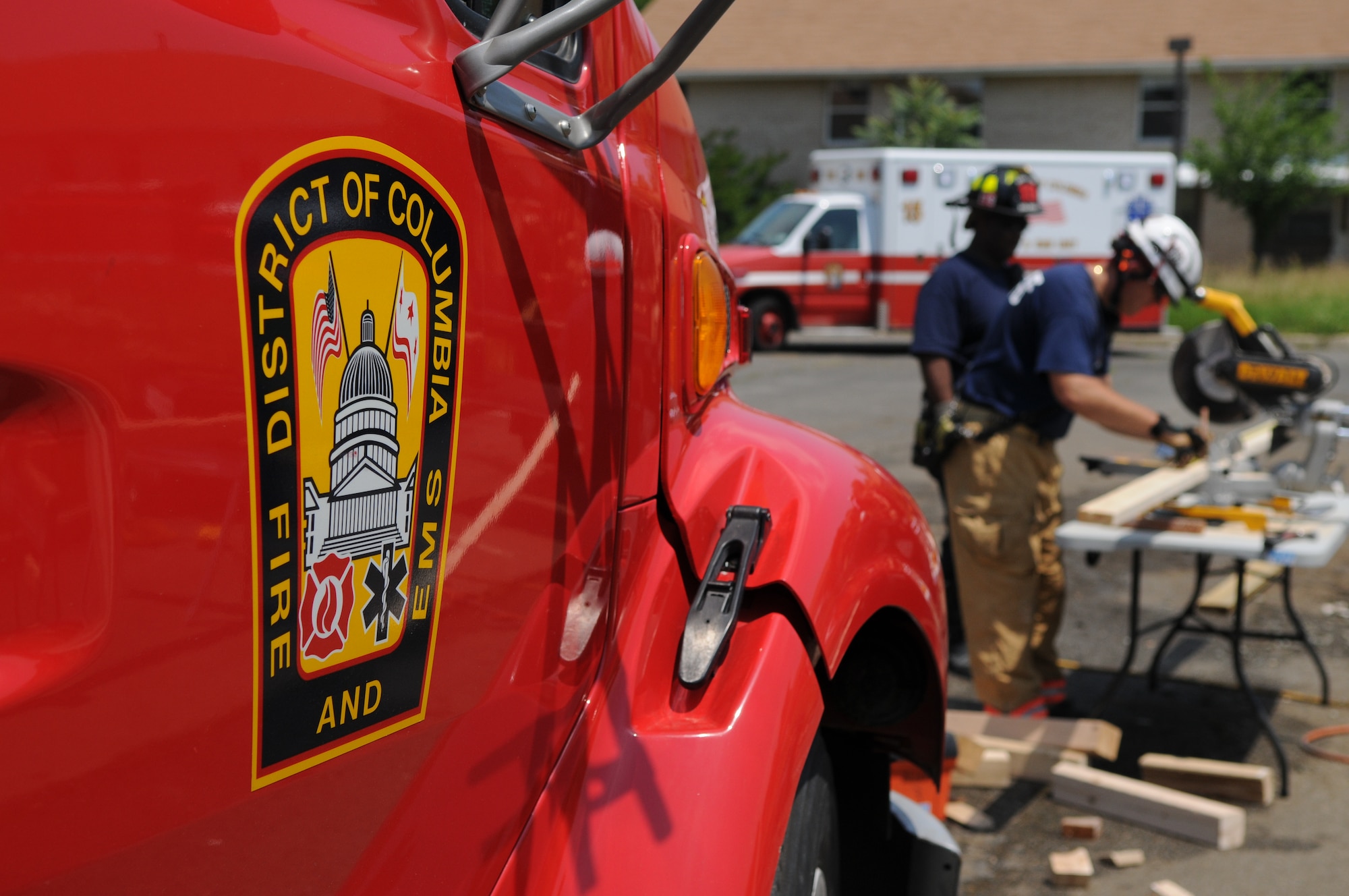 The Naval District of Washington Fire Department and the District of Columbia Fire Department cut wood to support a collapsed floor during a collapse-and-rescue exercise June 8 on Bolling Air Force Base. The impending demolition of Hickam Village housing created a prime location and opportunity June 1 - 12 for the joint training effort. (U.S. Air Force photo by Senior Airman Marleah Miller)