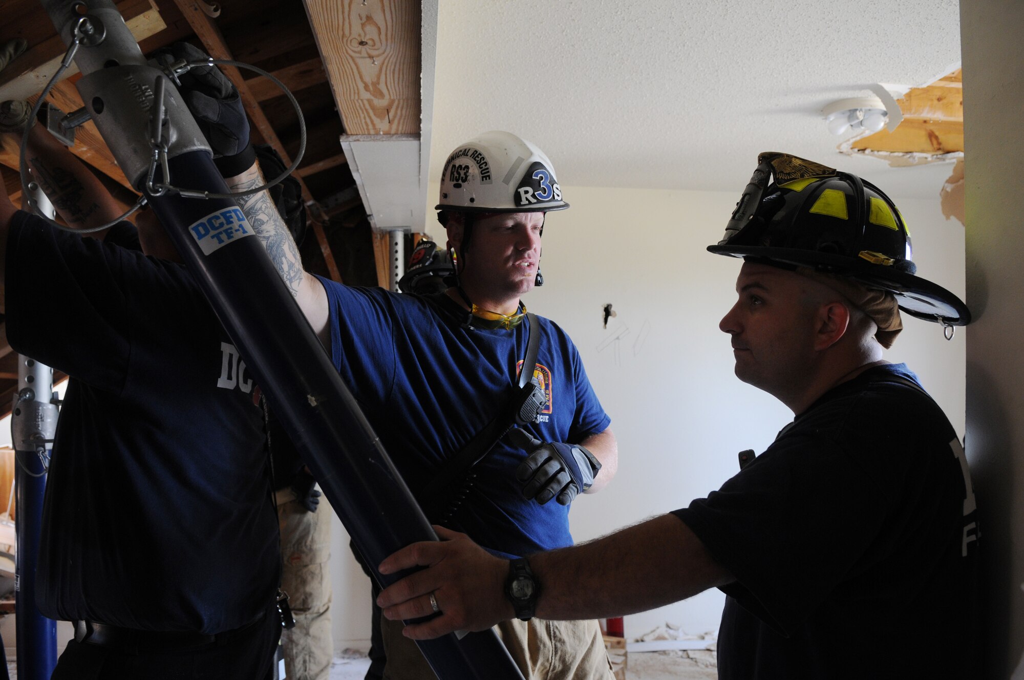 Mike Walker, District of Columbia Fire Department firefighter, explains to a Naval District of Washington firefighter on how to properly secure stands during a collapse-and-rescue exercise June 8 on Bolling Air Force Base. The NDWFD, in conjunction with the DCFD, conducted exercises June 1 - 12 in a condemned area of base housing that is scheduled for demolition. (U.S. Air Force photo by Senior Airman Marleah Miller)