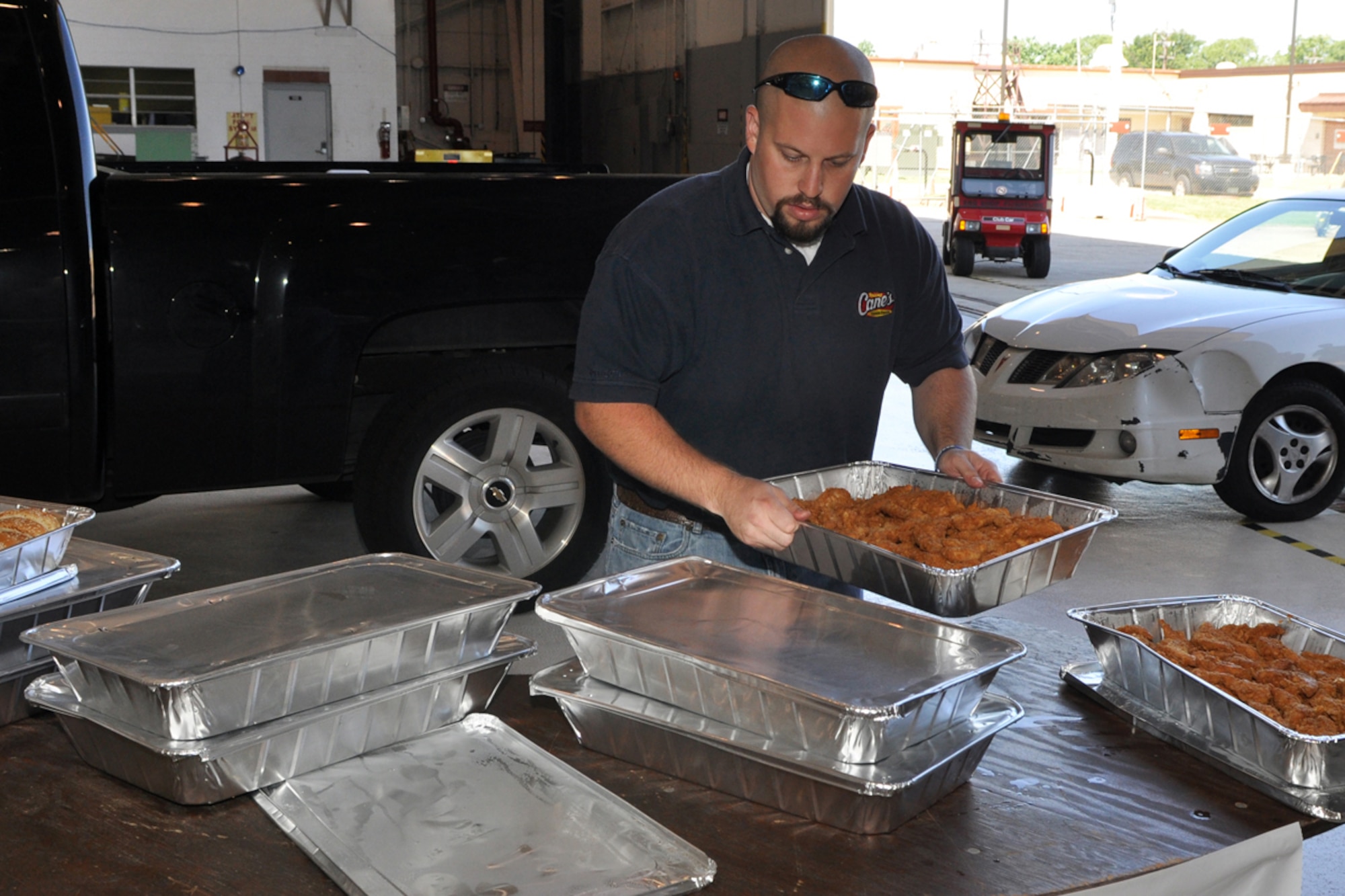 Pete John, general manager, Raising Cane’s Chicken Fingers restaurant #62 Pierre Bossier Mall, prepares to serve lunch to more than 400 Airmen from the 917th Wing at Barksdale Air Force Base, La., June 5, 2009. Managers from several Shreveport-Bossier area restaurants pitched in to provide lunch in an effort to “do their part in supporting local men and women who serve our country every day.” (U.S. Air Force photo/Tech. Sgt. Jeff Walston) 