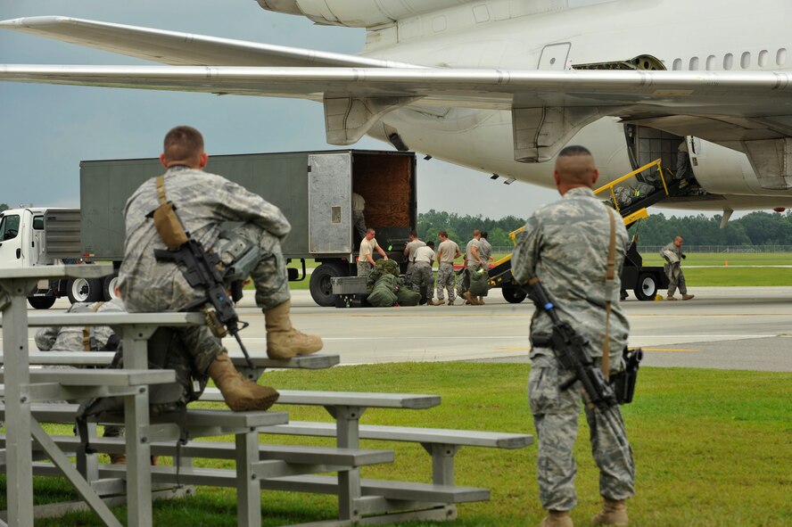 MOODY AIR FORCE BASE, Ga. -- Airmen from the 822nd Security Forces Squadron watch their mobility bags being loaded onto an aircraft here June 6. They are preparing to deploy to Camp Bucca, Iraq, to perform security operations and serve as convoy escorts. (U.S. Air Force photo by Senior Airman Schelli Jones)