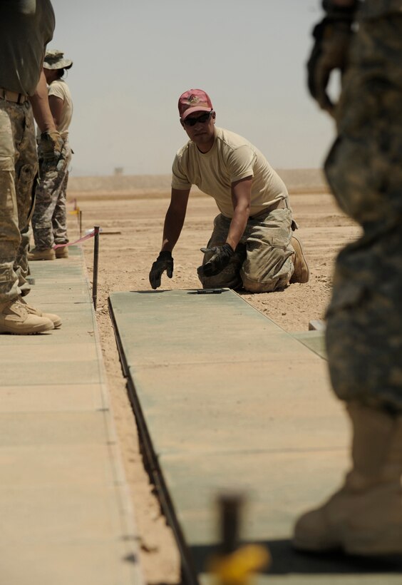 Staff Sgt. Michael Zamora prepares AN2 matting May 17 at Kandahar Airfield, Afghanistan. The ramp will be used to bed down combat aviation brigade helicopter units. Sergeant Zamora is an 819th Expeditionary RED HORSE Squadron civil engineer electrician. (U.S. Air Force photo/Staff Sgt. James L. Harper Jr.) 