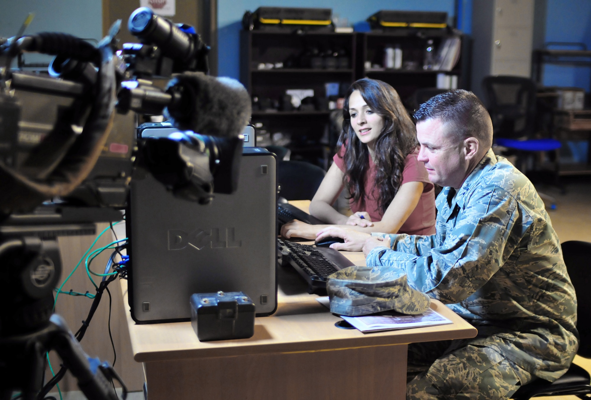 Capt. William Cooke watches NBC Channel 11 Alive news stories leading up to the live Web cast of his sons' graduation along with NBC Baghdad reporter Kianne Sadeq May 30 at Baghdad, Iraq. In addition to viewing the ceremony online, Captain Cooke's image was transmitted from Baghdad back to the Whitewater High School football field in Fayetteville, Ga., so he could be a part of the graduation. Captain Cooke is deployed from Tyndall Air Force Base, Fla., serving a six-month tour assigned to Multinational Force-Iraq at Camp Victory. (U.S. Army photo/Master Sgt. Michael Daigle) 
