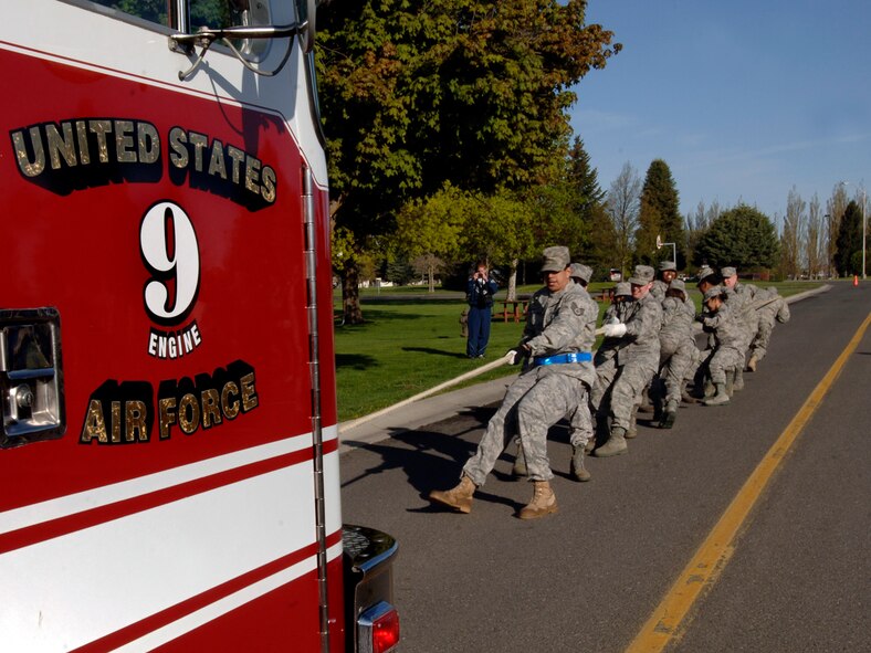 Members of the 92nd Force Support Squadron pull a fire truck across a finish line during the commanders challenge at Miller Park here May 15. The fire truck pull was one of four events in the Commander’s Combat Challenge. The 92nd Civil Engineer Squadron was victorious in the fire truck challenge. (U.S. Air Force photo / Airman 1st Class Melissa L. Carlino)