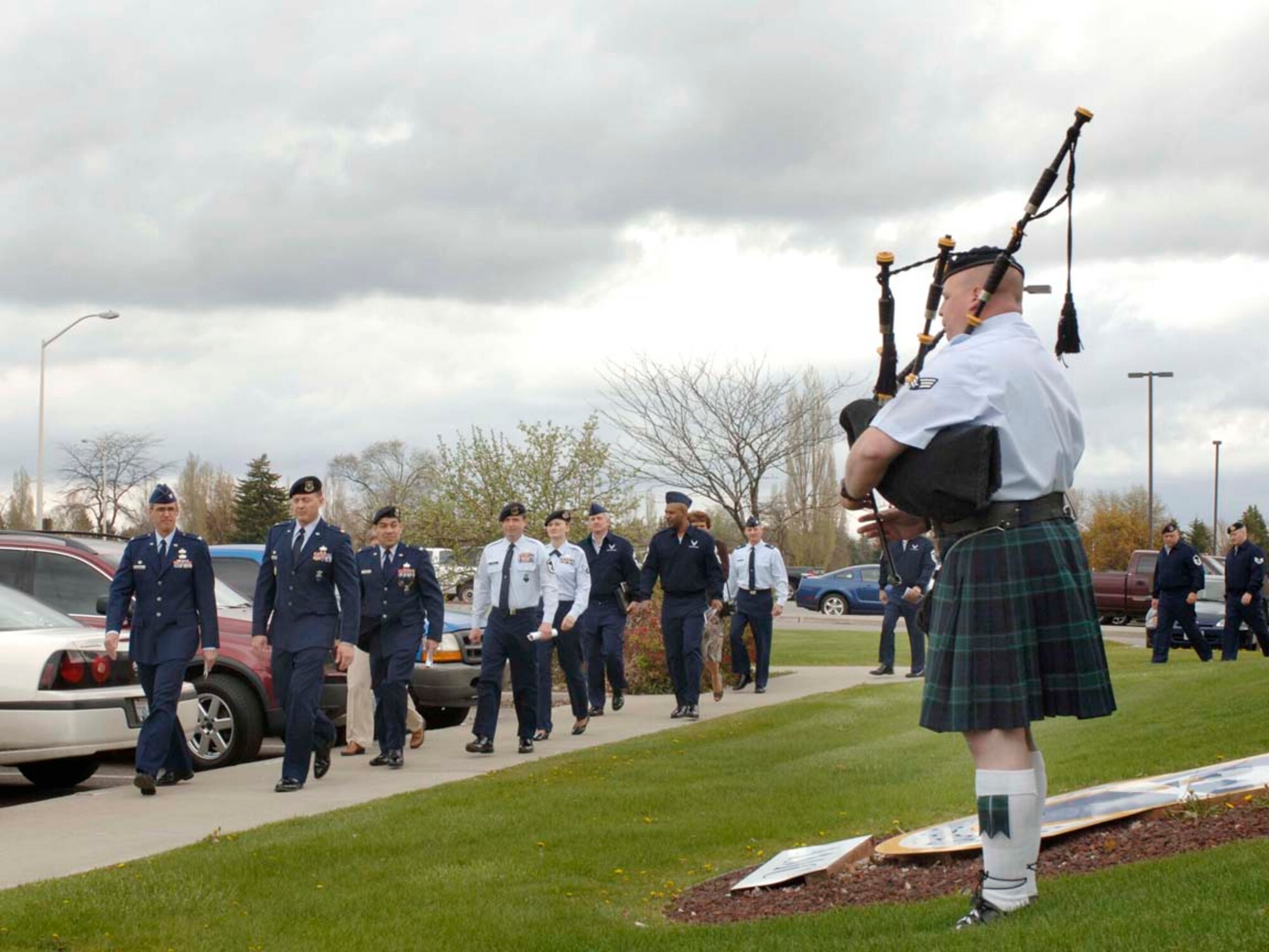 Senior Airman Dan Grimes, 141st Security Forces Squadron, plays Amazing Grace on the bagpipes as guests walk by the 92nd Security Forces Squadron to view the wall here May 11. (U.S. Air Force photo / Airman 1st Class Darlene West)