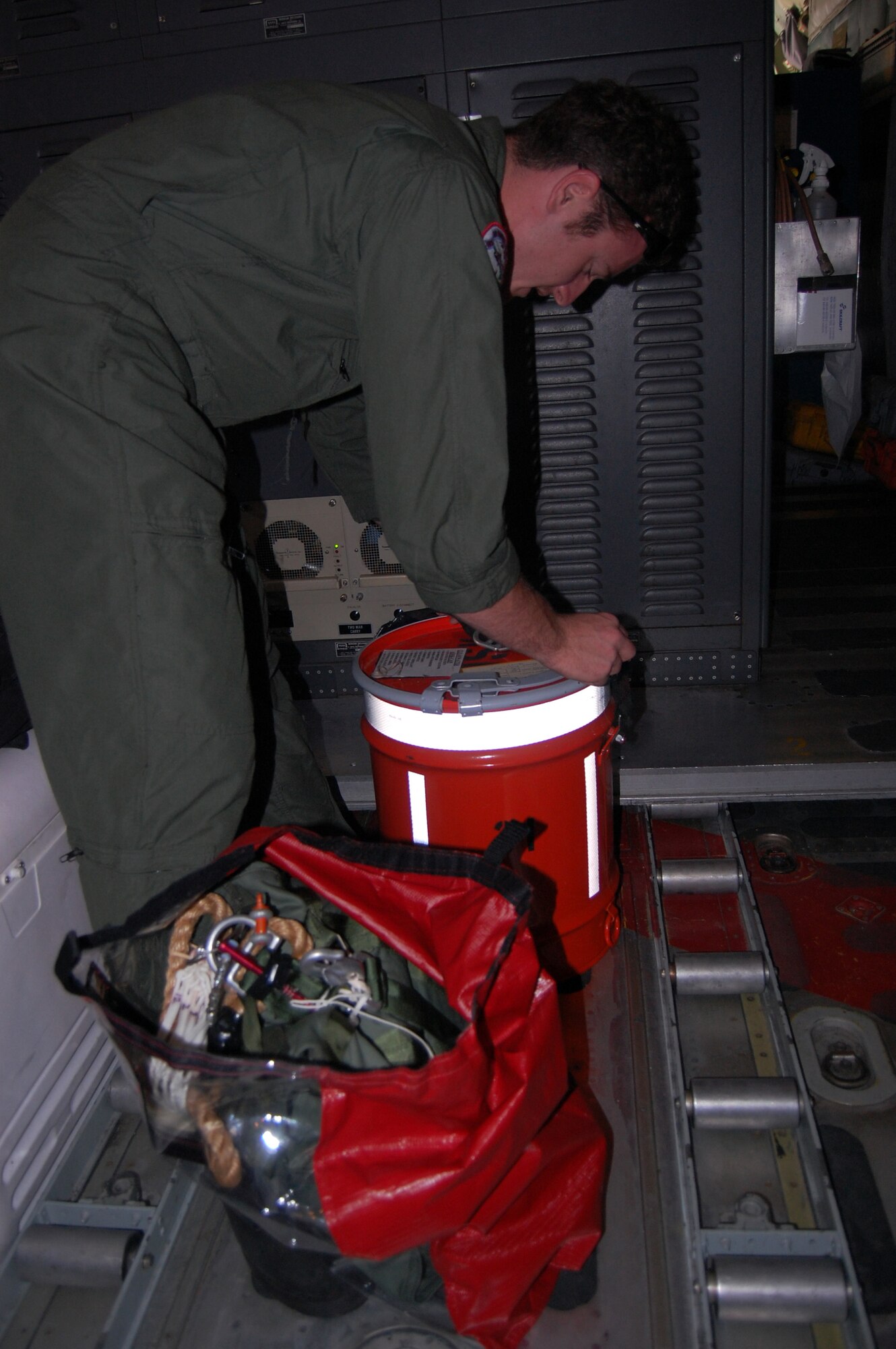 A member of a U.S. Coast Guard crew flying from FOL Manta, Ecuador, inspects a container holding a radio and water, similar to the one deployed from their C-130 June 2 to aid Ecuadorian fishermen in distress in the eastern Pacific Ocean. The crew is stationed at Air Station Clearwater, Fla. (U.S. Air Force photo by 1st Lt. Beth Woodward)
