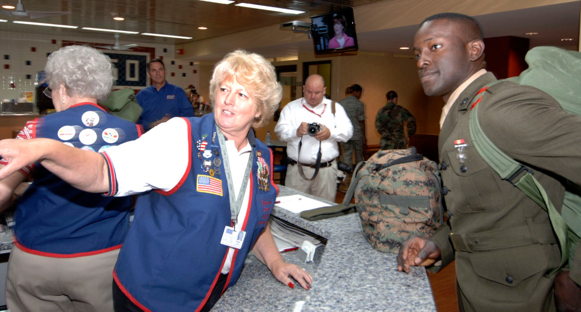 USO volunteer Sandy Ernst of Belleville shows the luggage check-in area to a young Marine on his way to Fort Leonard Wood, Mo. The USO at Lambert Airport in St. Louis re-opened June 3, 2009, after $300K worth of renovations gifted through the efforts of Dave Glover, 97.1 FM radio talk show host, and Marc Bulger, St. Louis Rams. Citing that "nothing is too good for our troops" the two gentlemen headed fundraising effort for the renovations that feature a child play/sleeping area, cyber cafe, gaming room, expanded media room, remodeled canteen and dining area, changing room and a larger luggae storage area. Representing the base was Col. Gary Goldstone, 375th Airlift Wing commander, who said the USO is a home to our troops wherever it may be and thanked them for their continued support of the nation's servicemembers. (Photo by Karen Petitt/375 AW/PA)