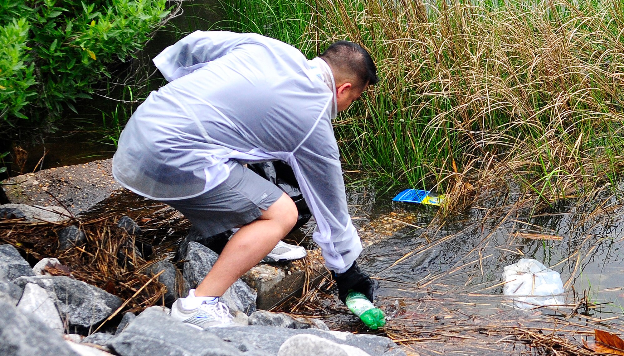 LANGLEY AIR FORCE BASE, Va. -- Tech. Sgt. Gareth Abrenica, Air Combat Command Director Staff Protocol, removes a plastic bottle from the Chesapeake Bay during the 21st Annual Clean the Bay Day here June 6. More than 200 members from the 1st Fighter Wing and Air Combat Command volunteered for the Clean the Bay Day activities. The program was brought about by the Chesapeake Bay foundation to help keep the bay clean of trash and debris. (U.S. Air Force photo/Senior Airman Dana Hill)