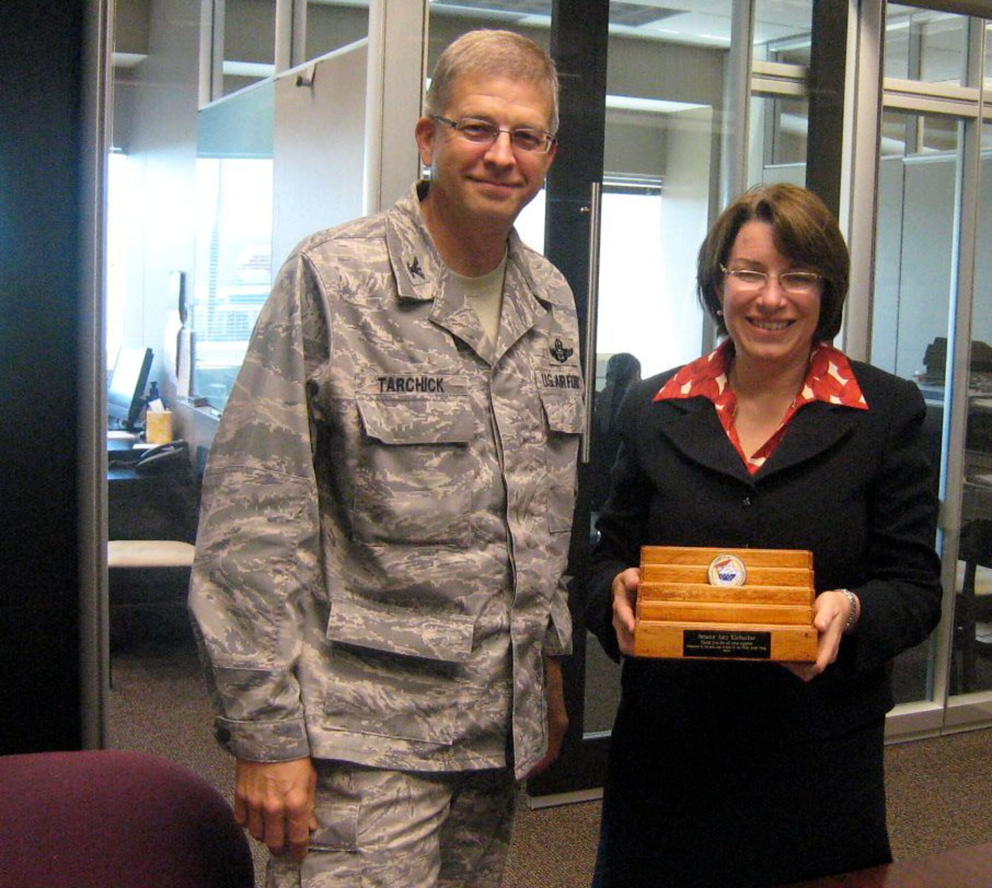 Col. Tim Tarchick, 934th Airlift Wing commander, presents Sen. Amy Klobuchar, with a 934th Airlift Wing coin and display rack in appreciation of her support for the men and women of the Wing. (Air Force Photo/Capt. S.J. Brown)