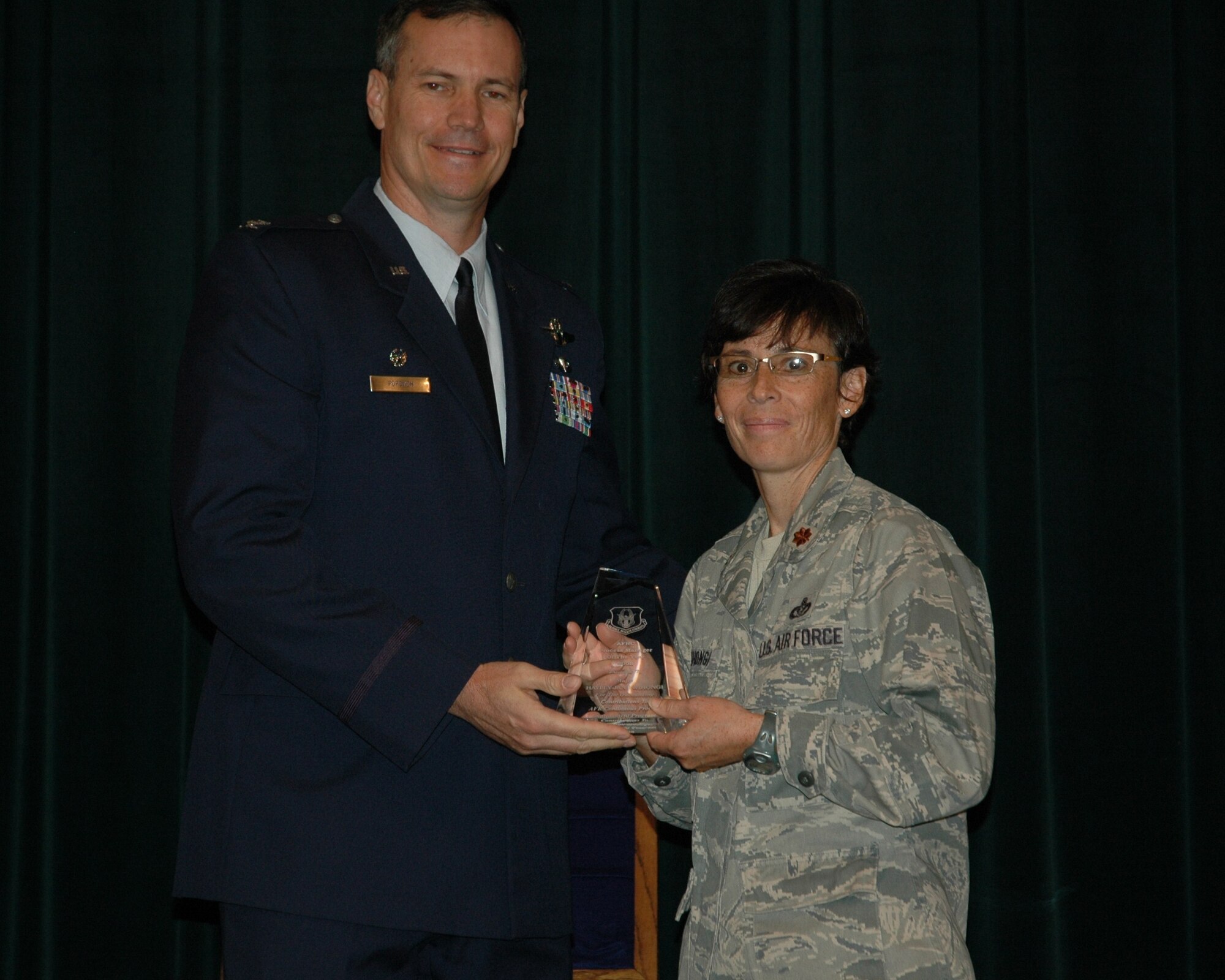 Col. Michael Popovich, 944th Fighter Wing commander, presents Maj. Haley Wihongi, 944th Fighter Wing, the award for Air Force Reserve Command Process Manager of the Year for 2008 during commander's call June 6. (U.S. Air Force photo/Tech. Sgt. Susan Stout)