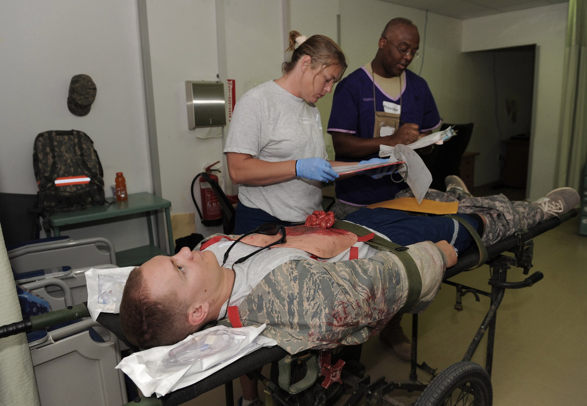 Staff Sgt. Jonathan Spell acts as a patient during a major accident response exercise as Capt. Sherri Hiser and Col. James Henderson attempt to provide care for his "wounds" June 5 at Joint Base Balad, Iraq. Sergeant Spell is a 332nd Expeditionary Logistics Readiness Squadron fuels resource controller. Captain Hiser is a 332nd Expeditionary Medical Operations Squadron registered nurse, and Colonel Henderson is the 332nd EMDOS intensive care unit director. (U.S. Air Force photo/Senior Airman Tiffany Trojca)