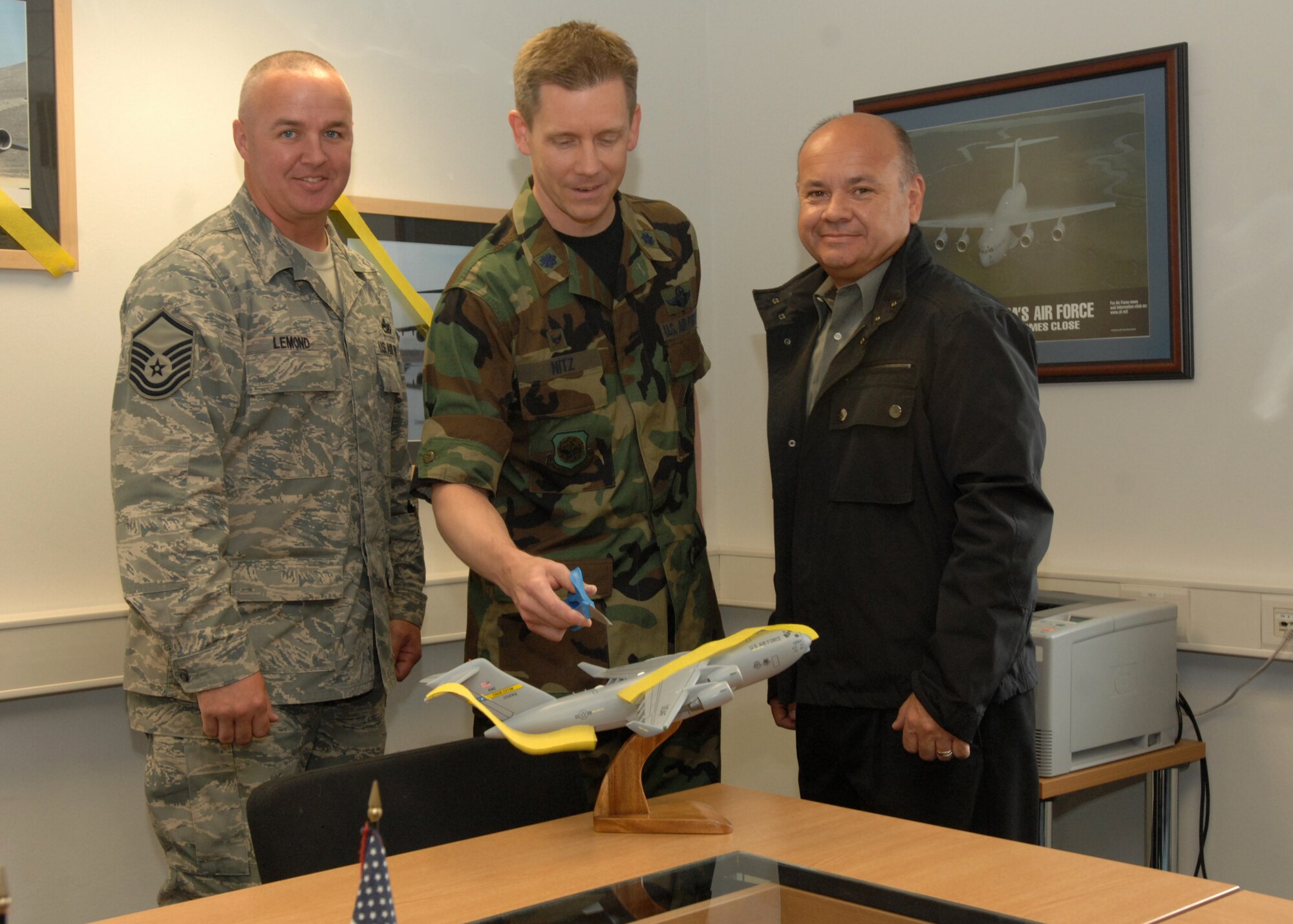 SPANGDAHLEM AIR BASE, Germany -- Master Sgt. Michael Lemmond, 52nd Force Support Squadron Airman Leadership School commandant; Lt. Col Trevor Nitz, 726th Air Mobility Squadron commander; and Eric Nolf, 726th AMS systems engineer and Boeing representative, cut the ribbon to the new Globemaster Classroom in the Spangdahlem Airman Leadership School June 4, 2009. The Airman Leadership School added the new Globemaster Classroom to commemorate one of the planes that is a part of Spangdahlem history and the significant role it plays for the 52nd Fighter Wing. (U.S. Air Force photo by Senior Airman Jenifer H. Calhoun)  