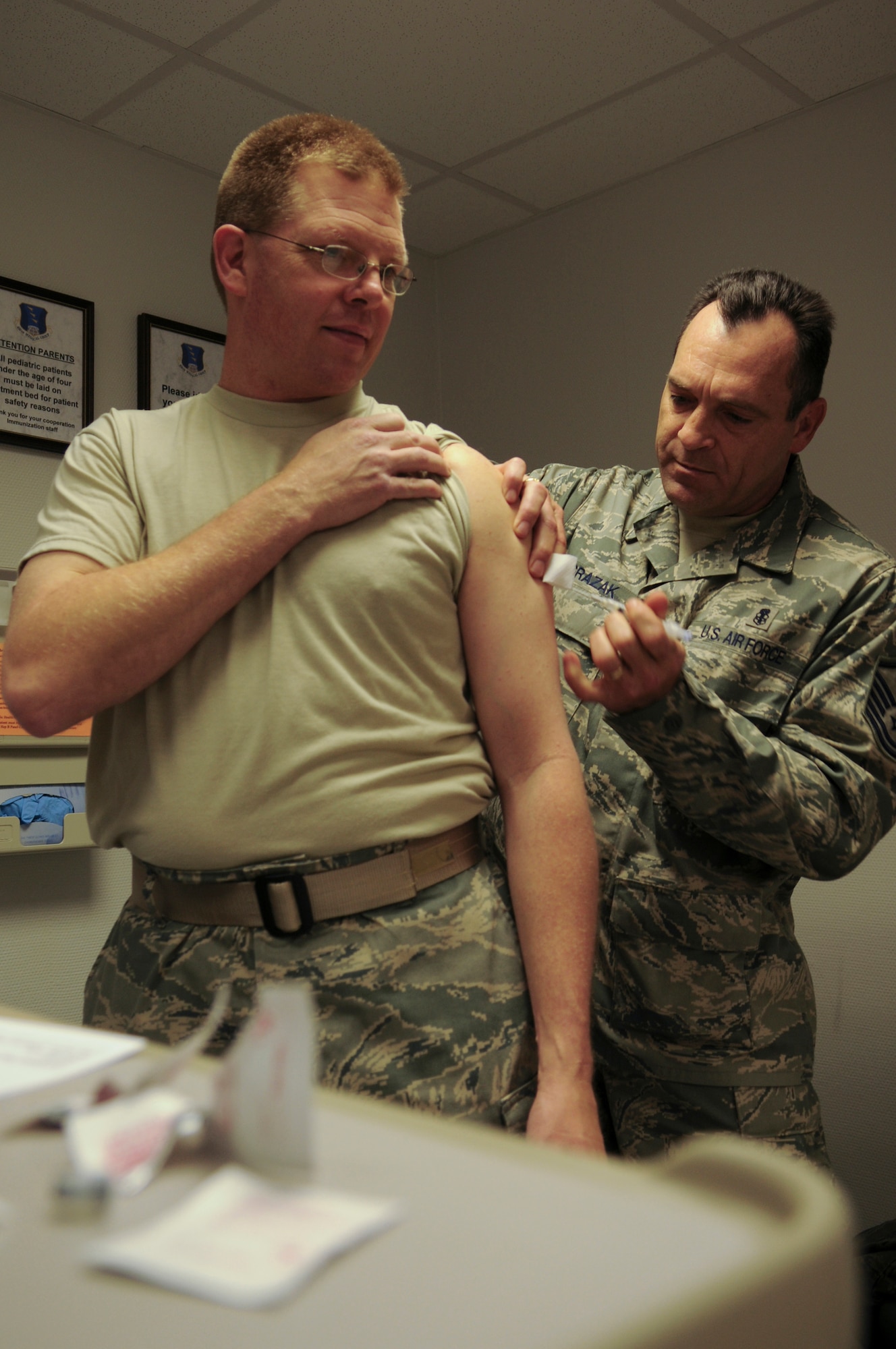 United States Air Force Master Sgt. Vance Grazak, 37th Airlift Squadron, senior independent duty medical technician assigned to the 435th Medical Group, administers a shot to Air National Guardsman Capt. Shane Pair, May 14, 2009, Ramstein Air Base, Germany. Captain Pair is a chaplain from the 188th Fighter Wing Arkansas Air National Guard, who is deployed to the 435th Contingency Aeromedical Staging Facility. (U.S. Air Force photo by Airman 1st Class Alexandria Mosness)