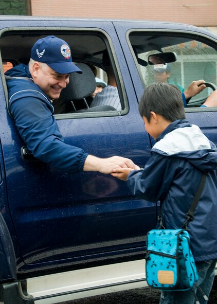 Chief Master Sgt. Rick Price, 35th Fighter Wing command chief, hands candy to a child during the American Day parade June 7 at Misawa Air Base, Japan. The parade was part of a weekend full of American entertainment and games. (U.S. Air Force photo/Staff Sgt. Araceli Alarcon) 