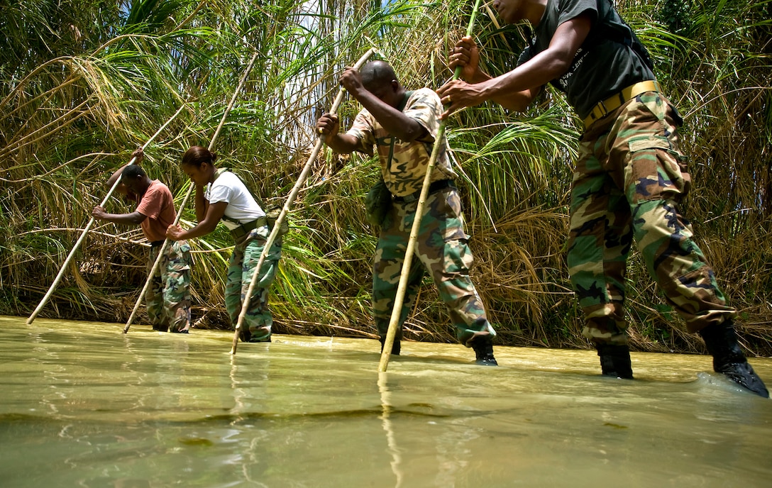Members of the Royal St. Lucia Police Force's Special Service Unit  make their way across a stream using measuring sticks while learning swiftwater rescue procedures taught by pararescuemen deployed for Operation Southern Partner, La Toc, St. Lucia, June 5, 2009. Operation Southern Partner is a long term commitment between U.S. and  partner nations to share experiences, information, vital skills, tactics and techniques in preparation for future regional challenges that require cooperative solutions.