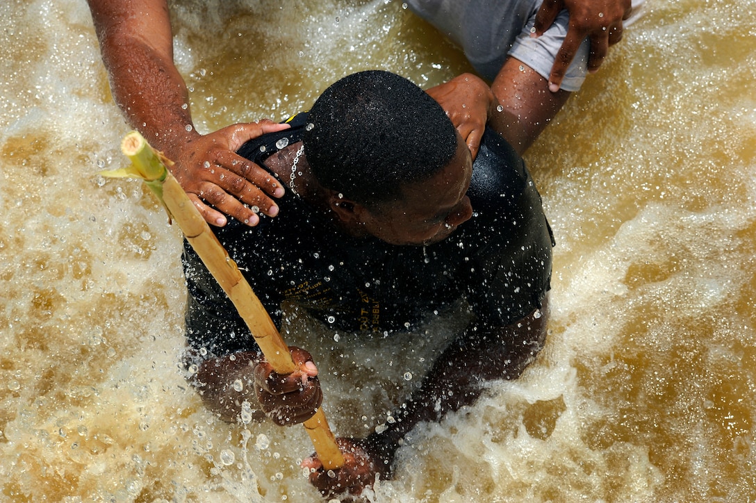Constable Damon Kangal, a member of the Royal St. Lucia Police Force's Special Service Unit, leads a team in a "wedge" formation while practicing swift-water rescue procedures taught by U.S. Air Force pararescuemen during Operation Southern Partner in La Toc, Saint Lucia, June 5, 2009.