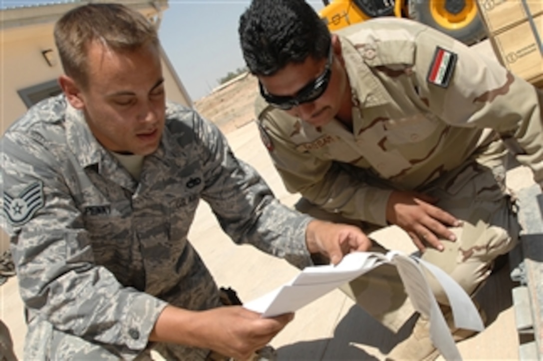 U.S. Air Force Staff Sgt. Christopher Penny, a combat munitions advisor with the 521st Air Expeditionary Advisory Squadron, reviews a shipment listing with Iraqi air force Warrant Officer Bassam Sehaam, a combat munitions specialist, at Kirkuk Regional Air Base in Iraq on June 1, 2009.  Penny, who is deployed from Eglin Air Force Base, Fla., is responsible for training Iraqi airmen on munitions loading procedures.  