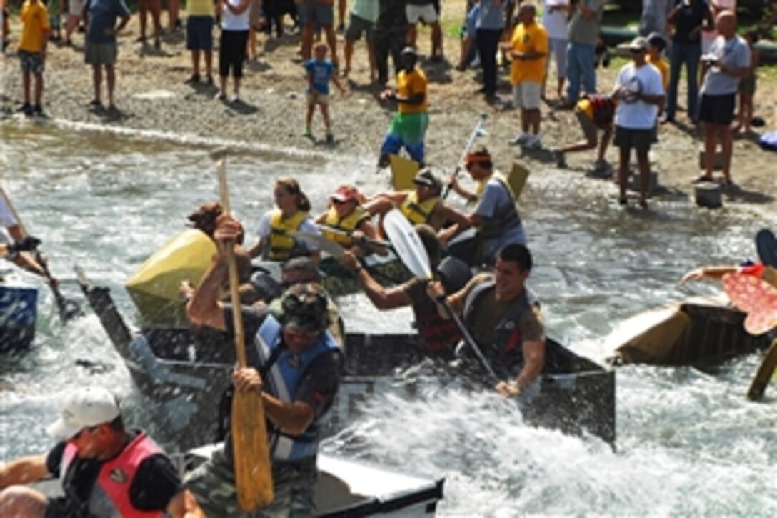 U.S. servicemembers paddle cardboard and duct tape boats at the Morale Welfare and Recreation Marina during a cardboard boat regatta in Guantanamo Bay, Cuba, May 30, 2009. The troops are assigned to the U.S. Naval Station Guantanamo Bay and Joint Task Force Guantanamo.