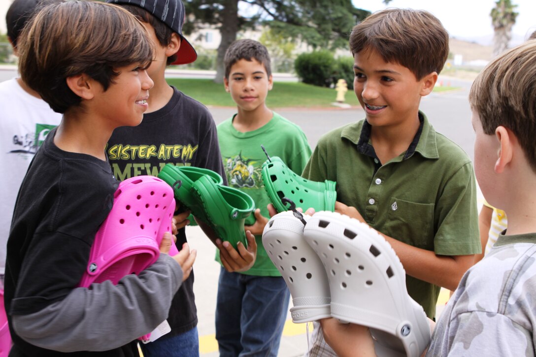 Devin Diaz smiles with Crocs in hand while tallking to Eric Caraballo Ramirez about his brand new sandals in front of Mary Fay Pendleton Elementary School, June 8.