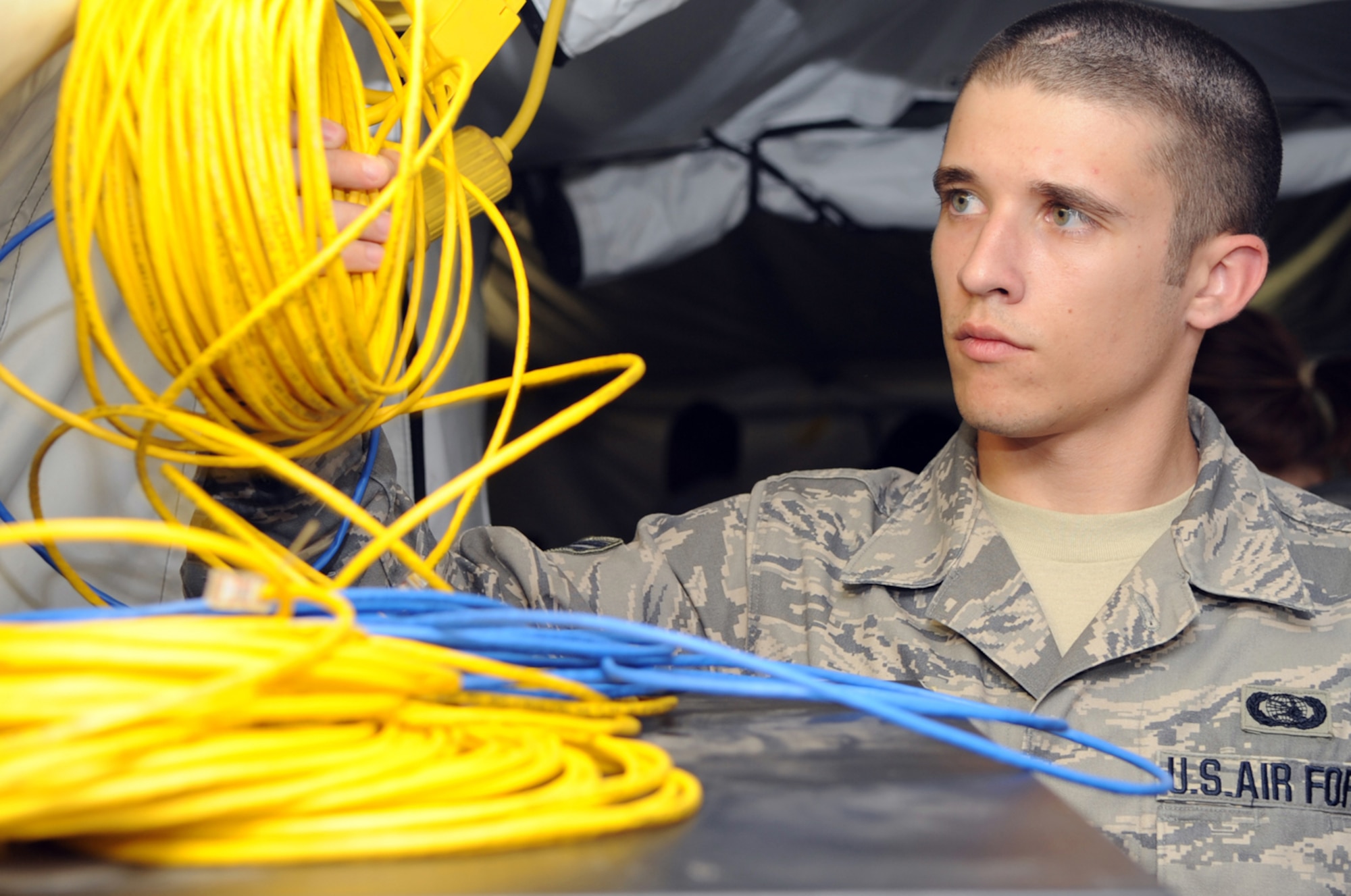 Airman 1st Class John Hammett of the 47th Intelligence Support Squadron prepares to connect the monitors that display command-and-control elements essential to the Rescue Operations Center at Exercise Resolute Angel. The exercise, hosted by Laughlin Air Force Base, Texas, was conducted May 29 to June 4 in preparation for the upcoming hurricane season and was  (U.S. Air Force Photo/Master Sgt. Heather Cabral)