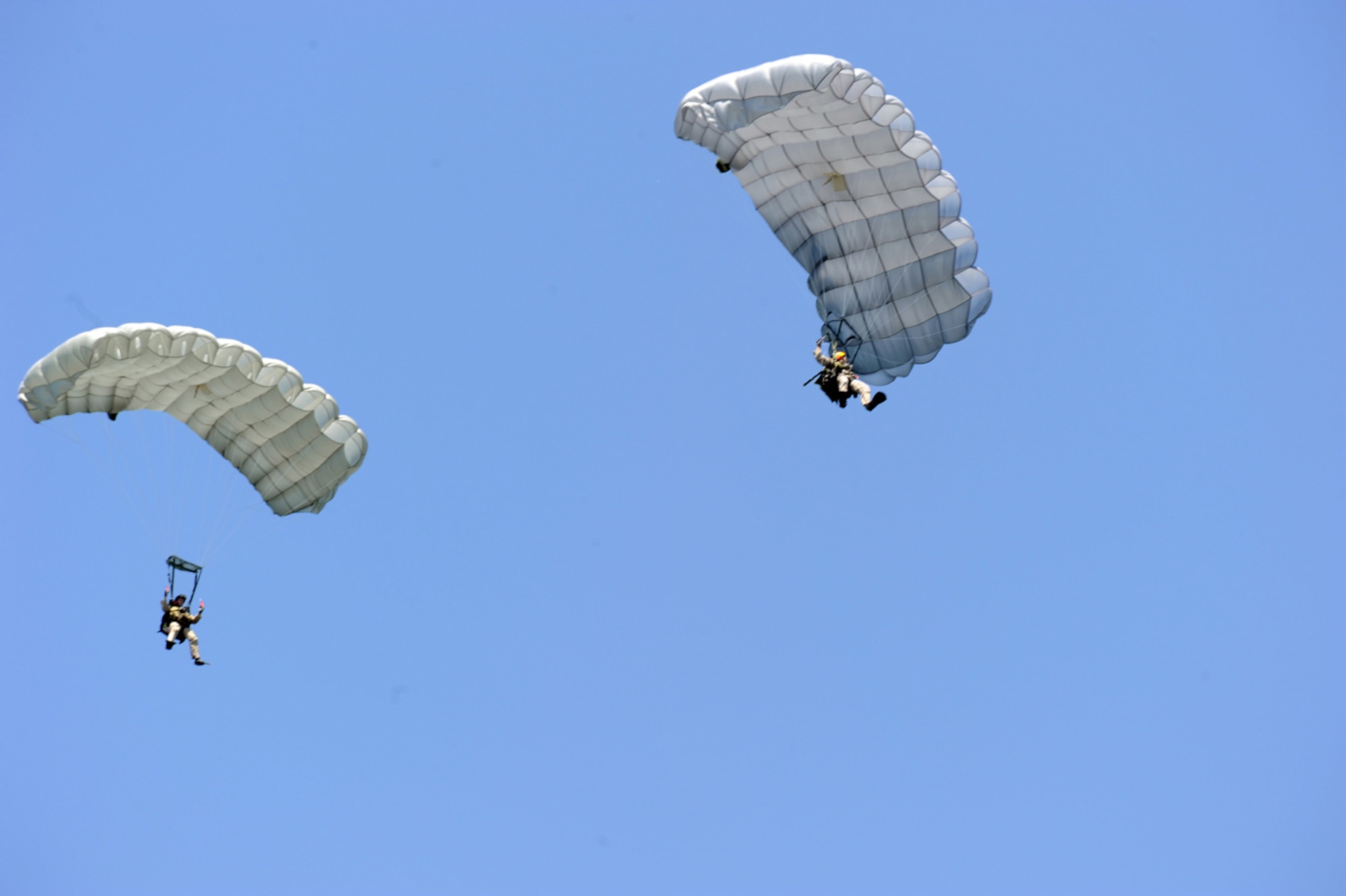 Capt. Mitchell Adams and Staff Sgt. Flores of the 48th Rescue Squadron descend after jumping out of a HC-130P Hercules during Exercise Resolute Angel. The exercise, hosted by Laughlin Air Force Base, Texas, was conducted May 29 to June 4 in preparation for the upcoming hurricane season. (U.S. Air Force Photo/Master Sgt. Heather Cabral)