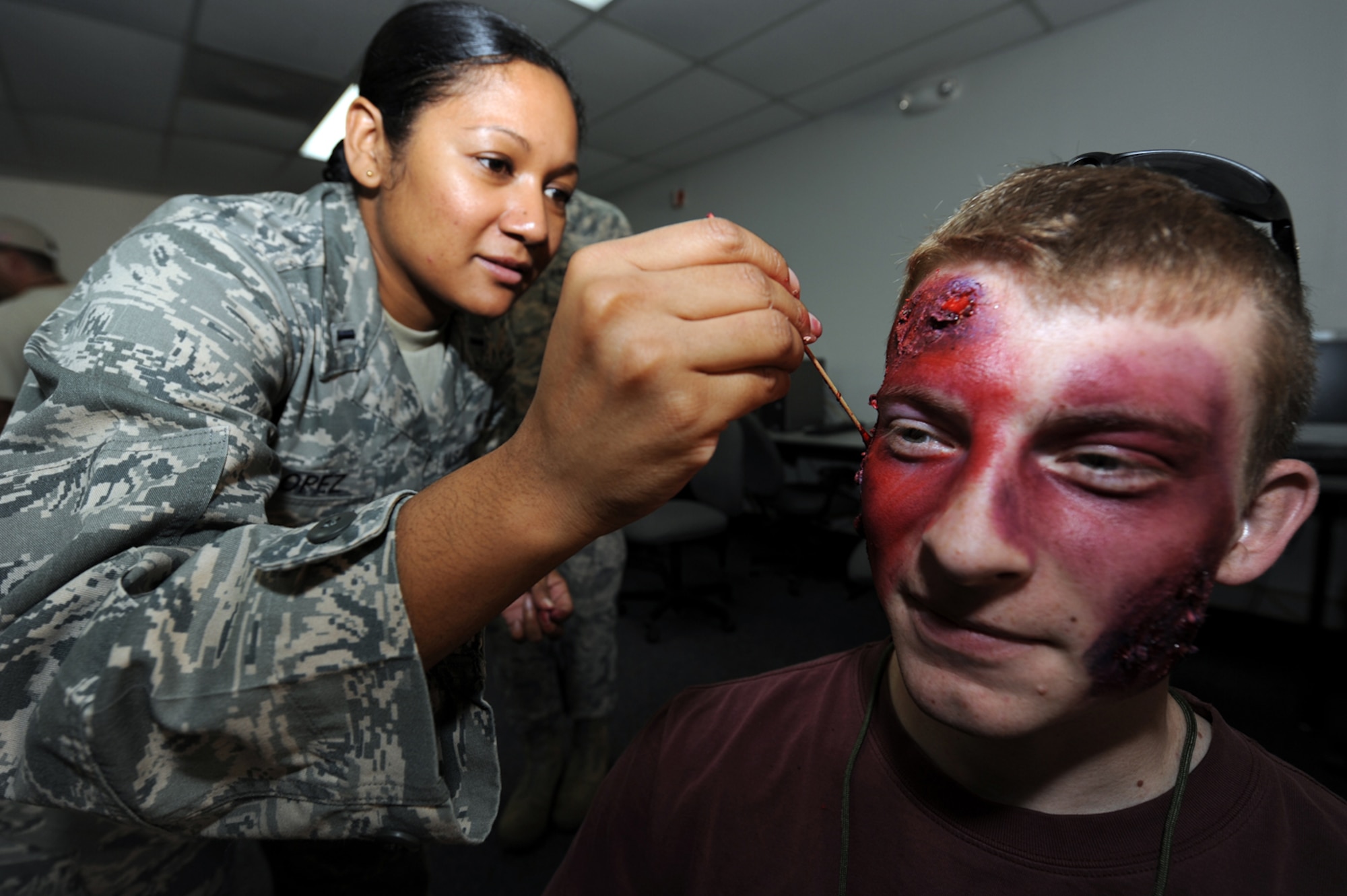 1st Lt. Vikki Lopez of the 47th Medical Support Squadron applies moulage to resemble a burn to 2nd Lt. Lucain Dekich of the 47th Operations Support Squadron. Survivors were staged with realistic injuries to test the pararescue Airmen's ability to treat their wounds during Exercise Resolute Angel. The exercise, hosted by Laughlin Air Force Base, Texas, was conducted May 29 to June 4 in preparation for the upcoming hurricane season. (U.S. Air Force Photo/Master Sgt. Heather Cabral)