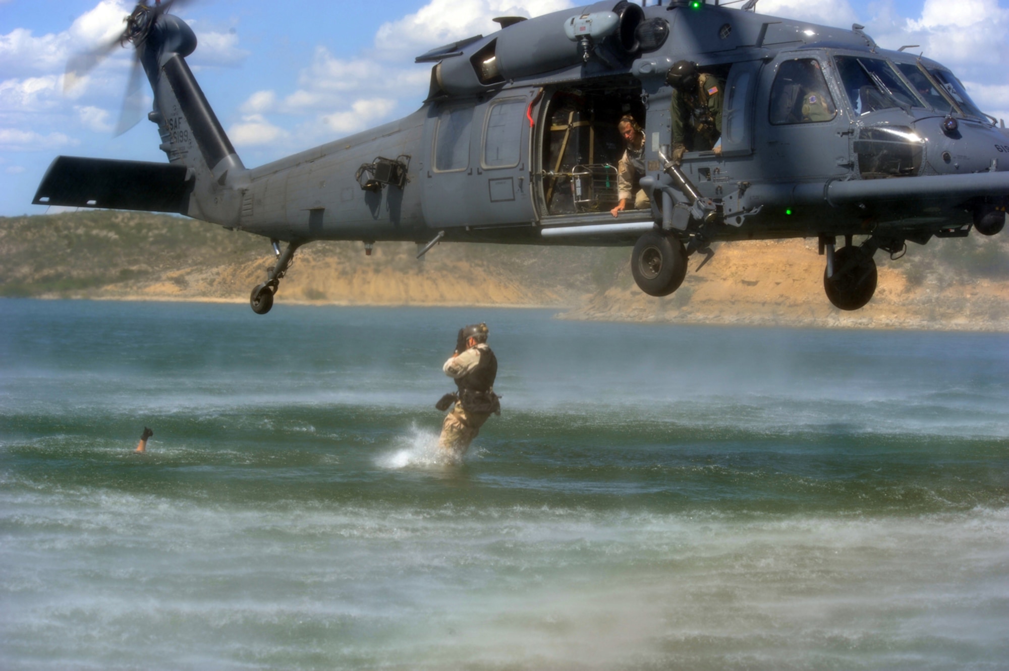Staff Sgt. Kevin Myerscough enters the water after jumping from an HH-60 Pave Hawk helicopter, while Master Sgt. Michael Atkins gives the safe thumbs-up and Senior Airman Brent Moore provides oversight. Exercise Resolute Angel, hosted by Laughlin Air Force Base, Texas, was conducted May 29 to June 4 in preparation for the upcoming hurricane season. All individuals pictured are members of the 48th Rescue Squadron at Davis-Monthan Air Force Base, Ariz. (U.S. Air Force Photo/Master Sgt. Heather Cabral)