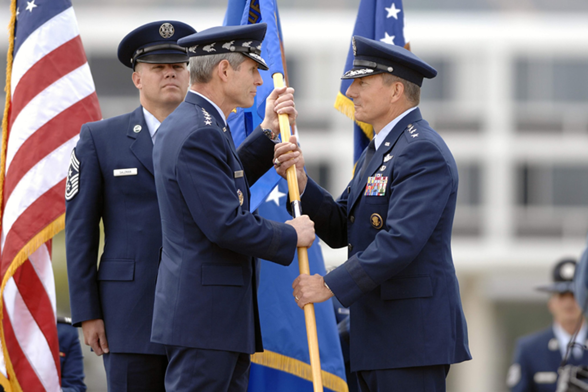 Lt. Gen. Michael Gould (right) accepts the U.S. Air Force Academy guidon from Gen. Norton Schwartz, chief of staff of the Air Force, during a change of command ceremony at the Academy June 9.  General Gould, a class of '76 Academy graduate, returns as the 18th superintendant, replacing Lt. Gen. John Regni, who is retiring.  Academy Command Chief Master Sgt. John Salzman waits to secure the unit flag following the exchange. (U.S. Air Force photo)