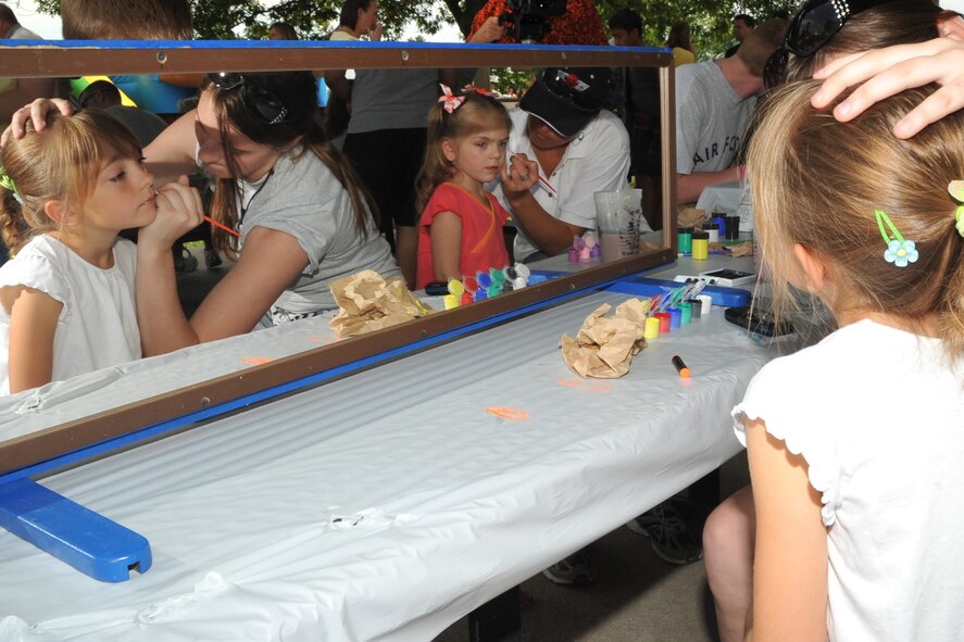 OFFUTT AIR FORCE BASE, Neb. -- Youngsters have their faces painted by volunteers while attending the 15th annual Offutt Appreciation Picnic at the Base Lake June 5. Picnic goers also enjoyed free food, children's rides, live entertainment and prize giveaways. U.S. Air Force photo by Jeff W. Gates