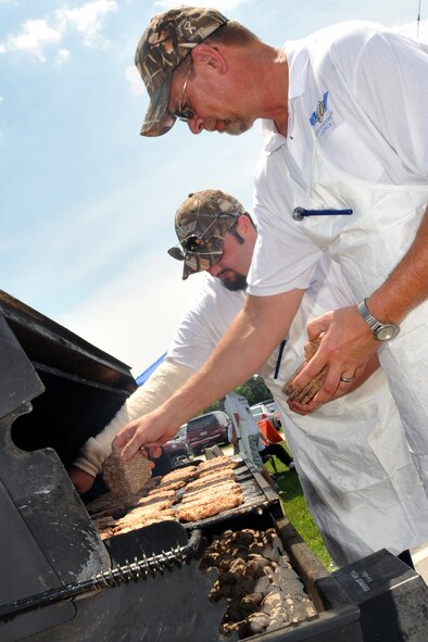 OFFUTT AIR FORCE BASE, Neb. -- Doug Johnson and Austen Adams, Volunteers with the Offutt Advisory Council, grill hamburgers during the 15th annual Offutt Appreciation Picnic at the Base Lake June 5. Along with hamburgers, picnic goers also enjoyed free bratwurst, hot dogs and drinks. U.S. Air Force photo by Jeff W. Gates