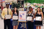 Defense Commissary Agency scholarship recipients Javier Williams, Ashley Hughes, Paige Carpenter and Michelle Wrights hold their certificates during a ceremony at the commissary on June 9. Seven Team Randolph family members earned $1,500 scholarships under DECA's "Scholarships for Military Children" Program, a program that rewards high school members for their community involvement and academic excellence. (U.S. Air Force photo by Don Lindsey)