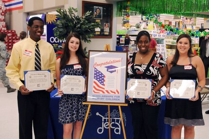 Defense Commissary Agency scholarship recipients Javier Williams, Ashley Hughes, Paige Carpenter and Michelle Wrights hold their certificates during a ceremony at the commissary on June 9. Seven Team Randolph family members earned $1,500 scholarships under DECA's "Scholarships for Military Children" Program, a program that rewards high school members for their community involvement and academic excellence. (U.S. Air Force photo by Don Lindsey)