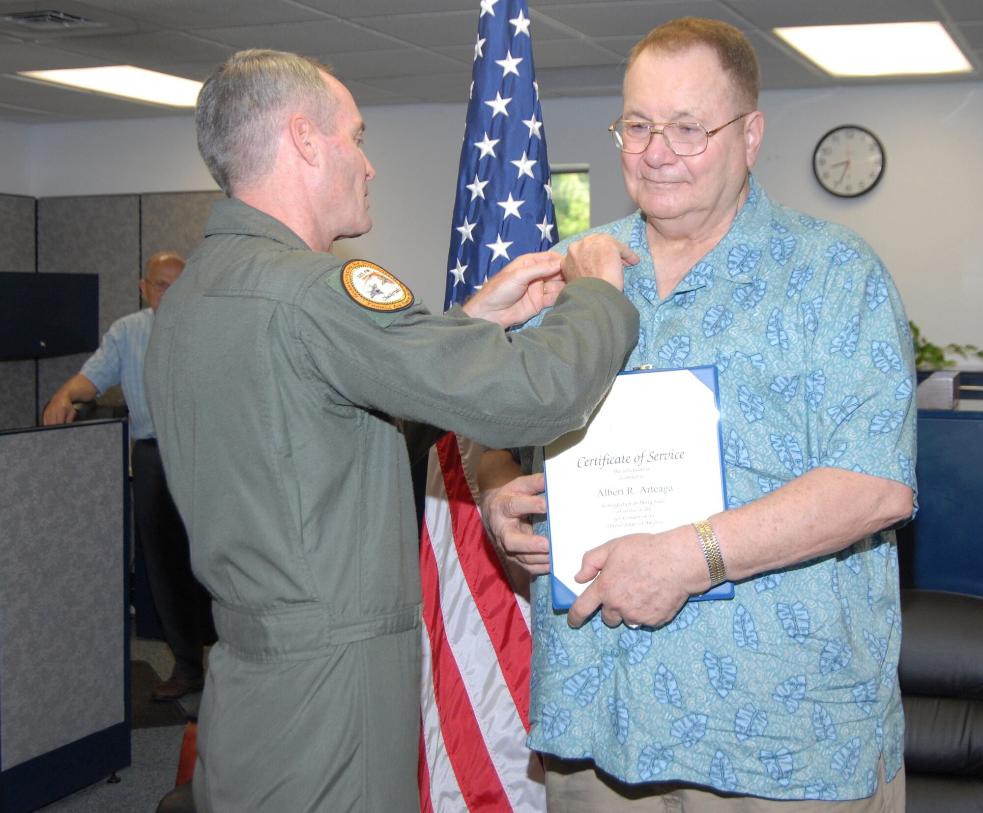 Brig. Gen. Darryl Roberson, 325th Fighter Wing commander, congratulates Albert Arteaga, 325th Medical Squadron purchasing clerk, for his 30 years in Civil Service with a pin here June 9.  (U.S. Air Force photo/Robin Walters)  