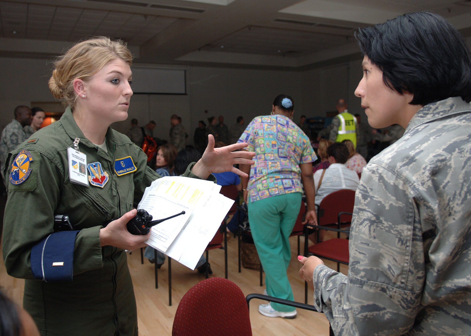 2nd Lt. Shawnalee Bradley, 49th Aeromedical Dental Squadron, reports to Capt. Mary Hay, 49th Medical Support Squadron, on building securing during the natural disaster exercise at Holloman Air Force Base, N.M., June 4. Officials reviewed checklists and accommodated all injured personnel at the Community Activity Center after a simulated tornado.  (U.S. Air Force photo/Airman 1st Class Veronica Stamps)