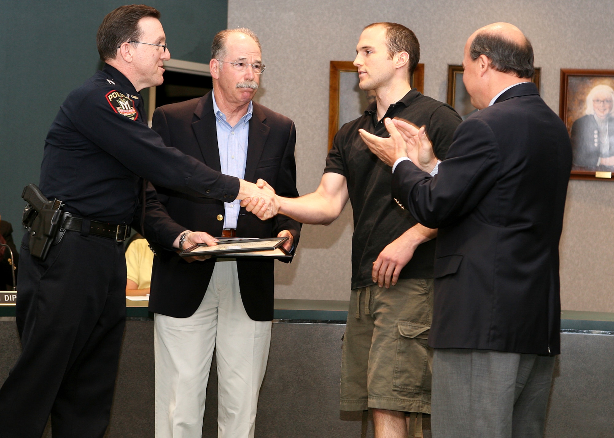 (Left to right) Brad Keil, Middleton Police Chief, Dr. Peter Karofsky, Staff Sgt. Tyson Hall, 115th Contracting Squadron, and Middleton Mayor Kurt Sonnentag stand together following a recognition ceremony for Sergeant Hall for his lifesaving rescue April 18 at Middleton High School. (Photo: Courtesy)