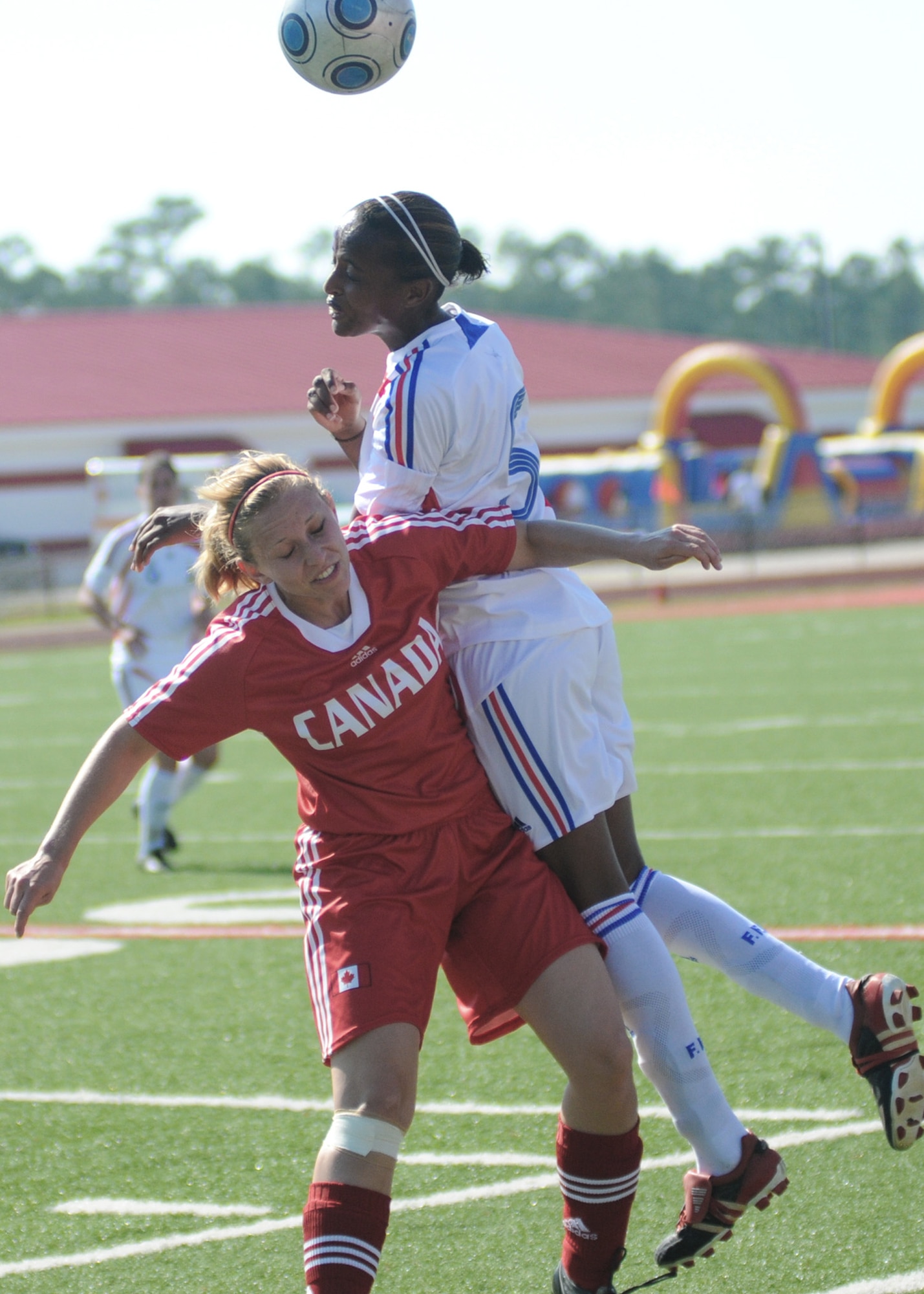 Soccer players from Canada and France compete during the 5th Counseil Du International Sports Militaire Women's Soccer Championship at Biloxi High School Stadium June 7 in Mississippi. The CISM tournament, hosted by officials from Keesler Air Force Base, Miss., includes teams from Brazil, Canada, France, Germany, The Netherlands, South Korea and the United States. (U.S. Air Force photo/Kemberly Groue)