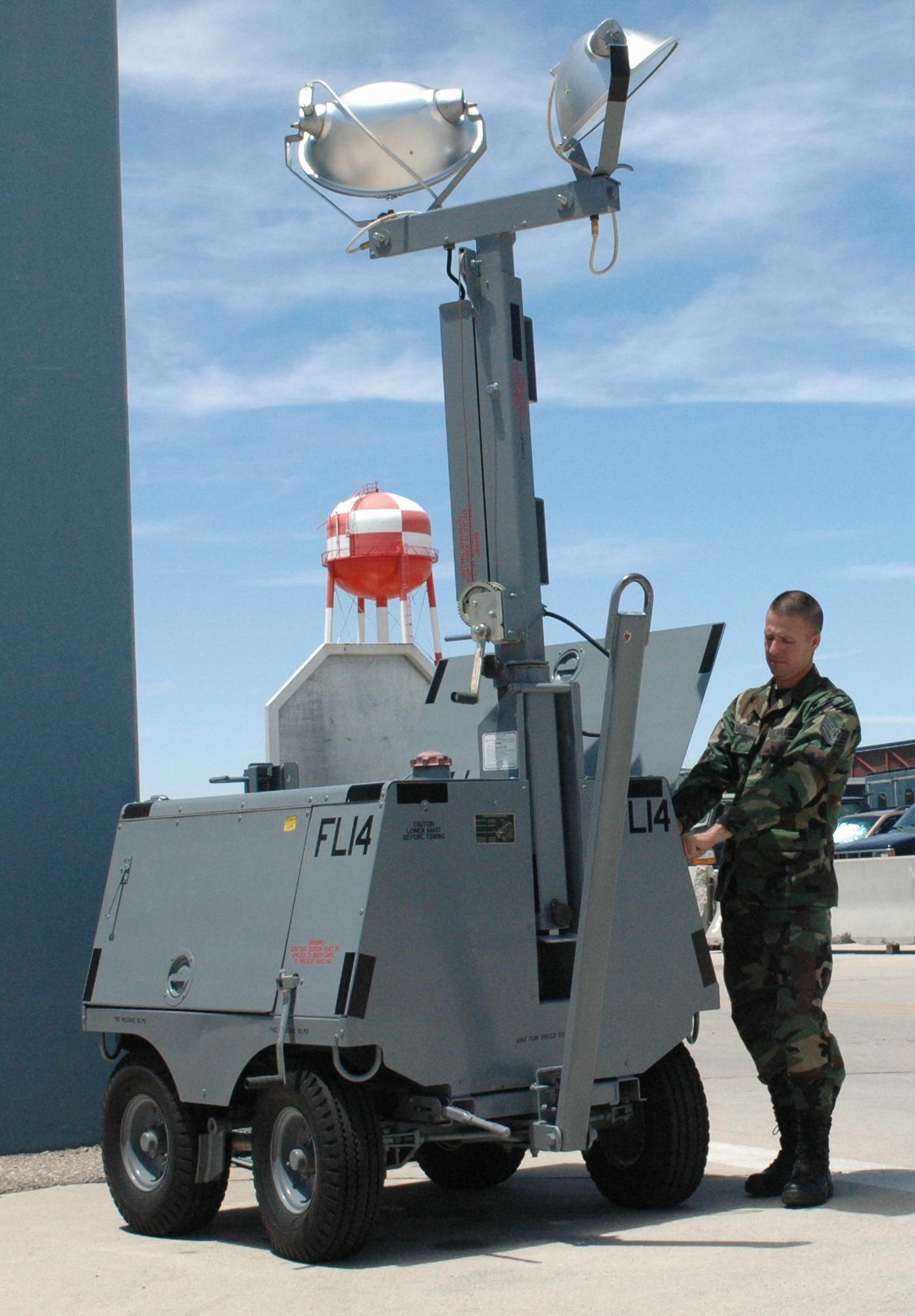 Tech. Sgt. Martin Buelow, a power support systems mechanic, performs maintenance on a Flood Light Model 1D on base. These flood lights, which run on JP-8 fuel, will soon be replaced by solar-powered lights that will greatly reduce the unit’s annual energy consumption. (Air National Guard photo by Krystal Tomlin)