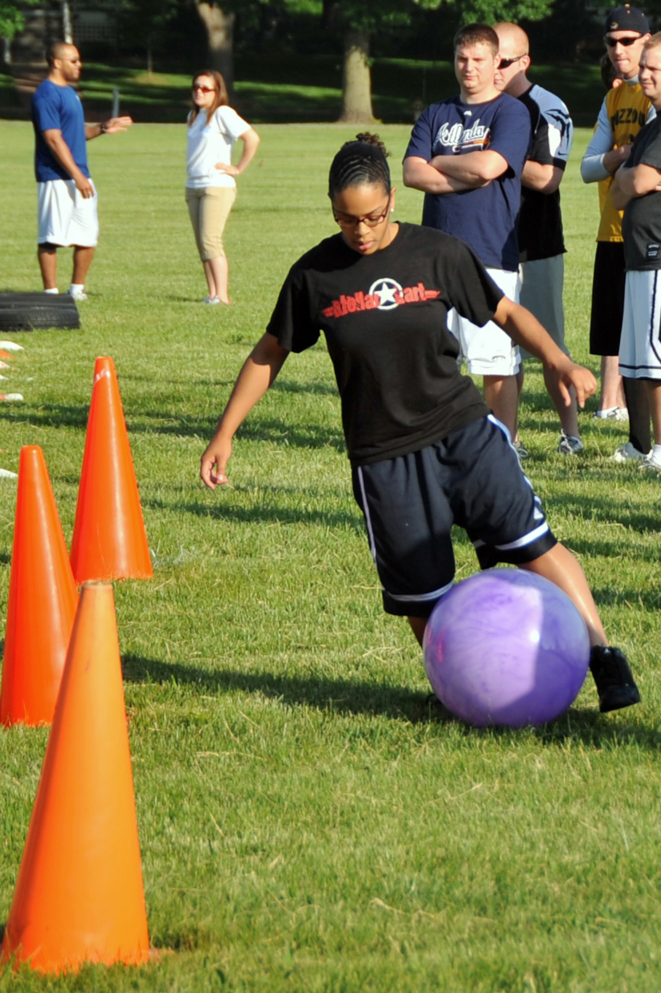 OFFUTT AIR FORCE BASE, Neb. -- Airman 1st Class Darliny Ayala, U.S. Strategic Command, manuevers a ball around cones as part of the obstacle course challenge during Offutt Sports Day at the parade grounds June 5. All base agencies competed in activities including tug-of-war, 110-yard dash and ultimate frisbee. Trophies were presented to the top 3 points gaining units from the combined events during the Offutt Appreciation Day picnic at the Base Lake later that day.
 U. S. Air Force photo by Jeff W. Gates