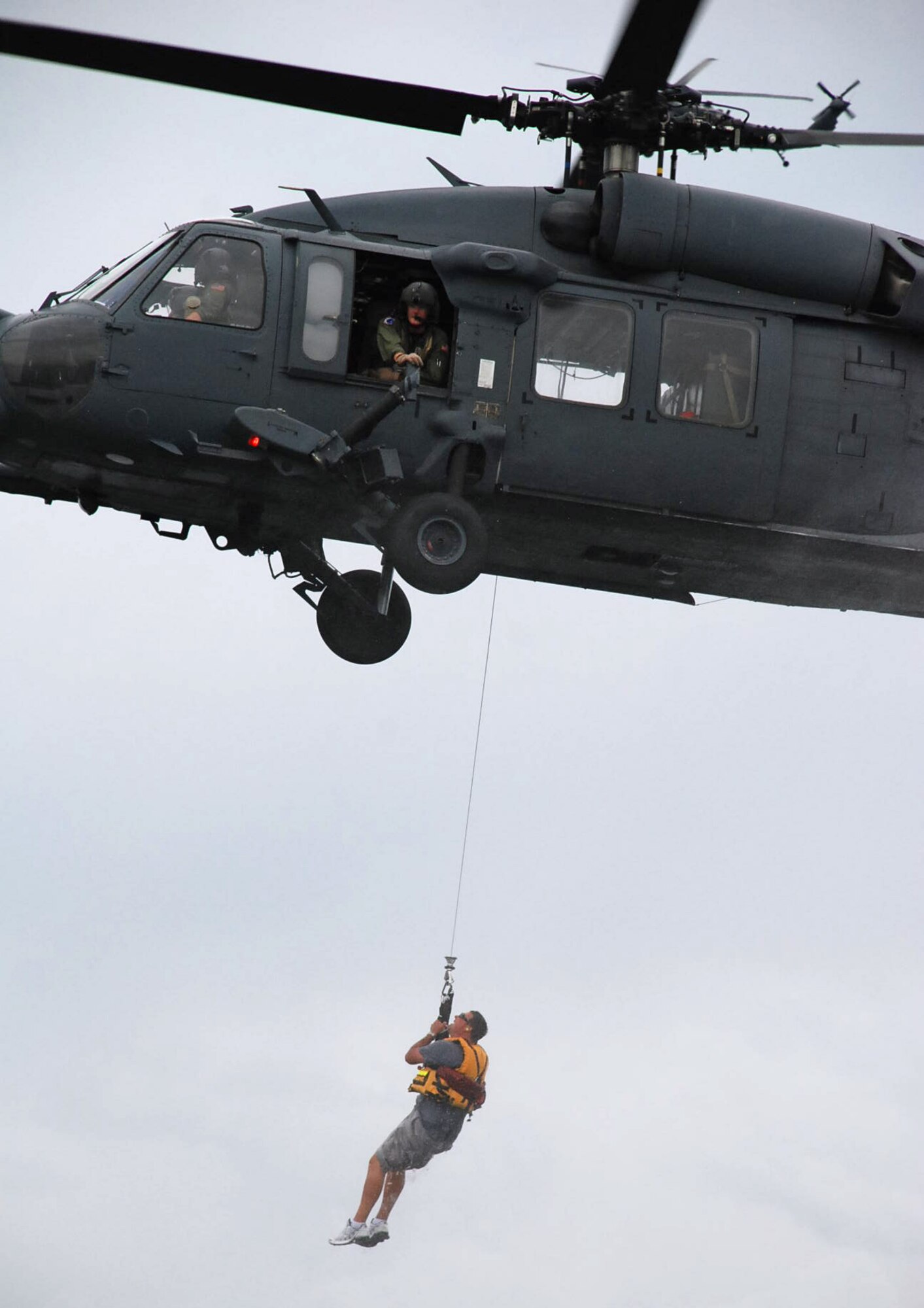 LAUGHLIN AIR FORCE BASE, Texas – Olin Jensen, Laughlin Fire Department crew chief, is hoisted onto a HH-60 Pave Hawk helicopter after a pararescue Airmen from Davis-Monthan Air Force Base, Ariz., performed a mock rescue with him during an exercise in Lake Amistad June 2. The exercise was held to prepare Laughlin, Davis-Monthan and the community for any potential natural disasters that could occur in the future. (U.S. Air Force photo by Airman 1st Class Sara Csurilla)