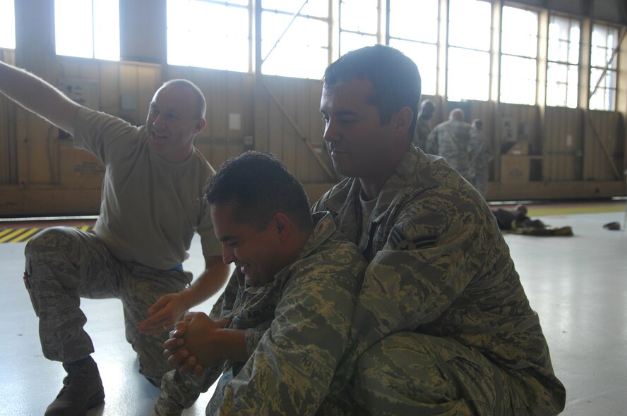 SHAW AIR FORCE BASE, S.C.-  Tech. Sgt. Bryan Hinton instructs Capt. Victor Menagarcia and Senior Airman Gary Anderson on the proper way to transport an injured person at the Ability to Survive and Operate Rodeo June 5, 2009. (U.S. Air Force Photo by: 2nd Lt. Emily Chilson)