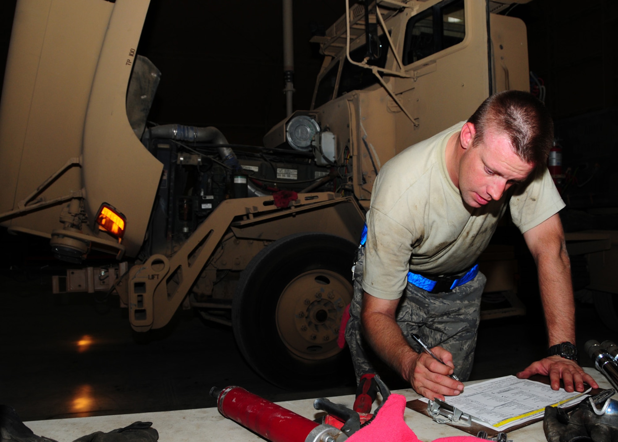 SOUTHWEST ASIA -- Staff Sgt. Brian Cook, 586th Expeditionary Logistics Readiness Squadron vehicle maintainer, signs off on a quality assurance quality check inspection sheet of a returning line haul trucking fleet at an Army base in Southwest Asia, June 8. Before and after a mission the trucks have to be fully inspected for any maintenance issues, from a flat tire to major repairs, to ensure the trucks are always mission ready. Sergeant Cook is deployed from McGuire Air Force Base, N.J., and hails from Portland, Ore. (U.S. Air Force photo/ Senior Airman Courtney Richardson)