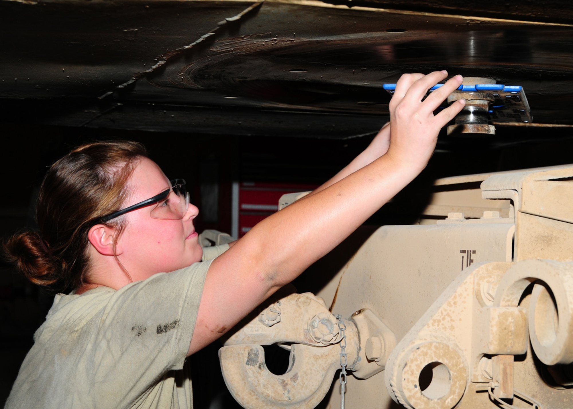 SOUTHWEST ASIA -- Senior Airman Desiree Morlock, 586th Expeditionary Logistics Readiness Squadron vehicle maintainer, measures the wear of the king pin gauge under a line haul truck trailer at an Army base in Southwest Asia, June 8. The vehicle maintainers check for mounting and wear and also examine the kingpin to see if it extends the proper length from the trailer bearing plate and that the lower flange is of specified size to prevent disengagement of the kingpin from the fifth wheel jaws. The kingpin connects the trailer to the truck. Airman Morlock is deployed from F.E. Warren Air Force Base, Wyo., and hails from Akron, Ohio. (U.S. Air Force photo/ Senior Airman Courtney Richardson) 