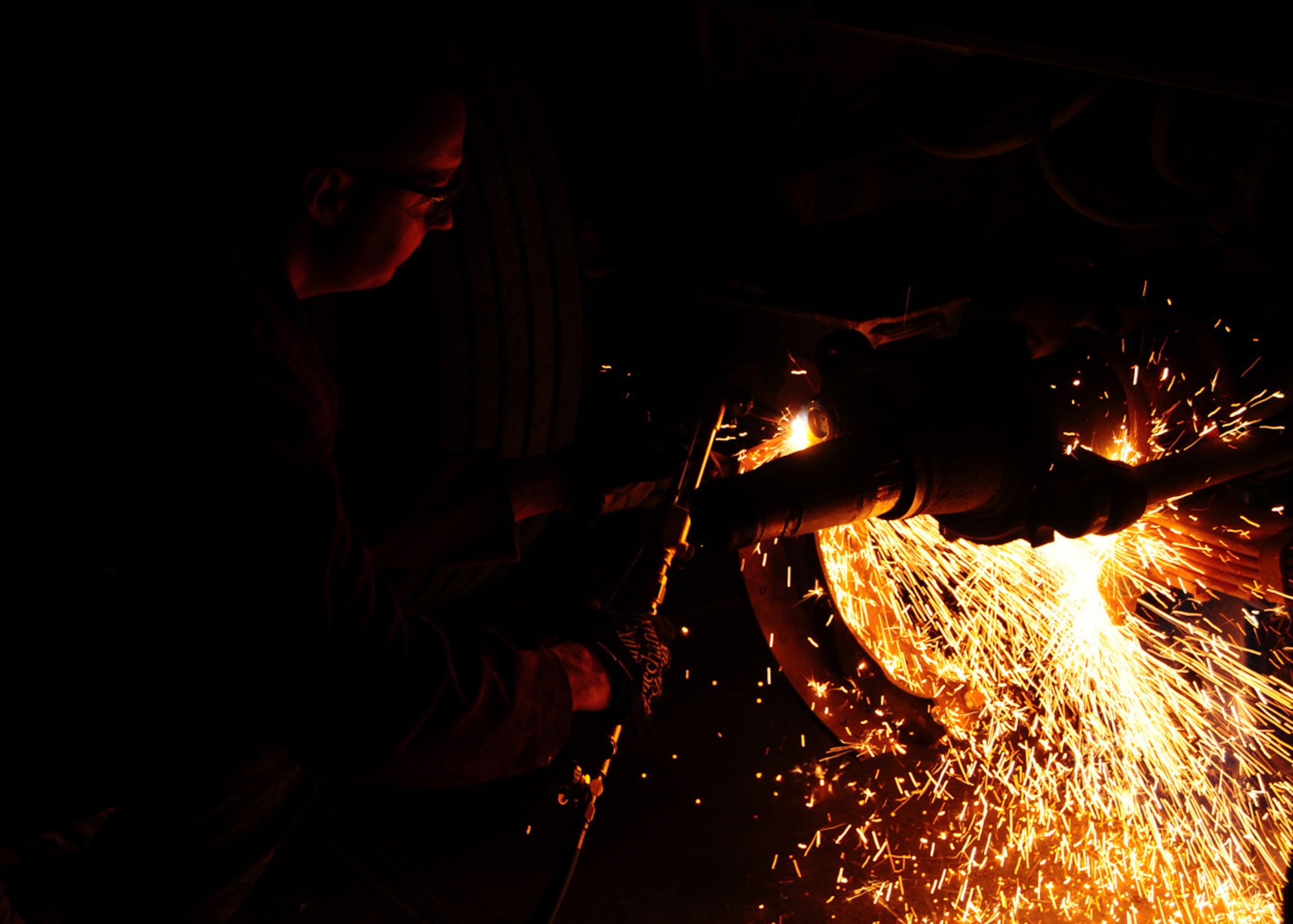 SOUTHWEST ASIA -- Staff Sgt. Lukas Wilber, 586th Expeditionary Logistics Readiness Squadron vehicle maintainer, uses an oxyacetylene torch to cut off metal to remove a corroded pin from a truck's braking system at an Army base in Southwest Asia, June 8. Cutting is initiated by heating the edge or leading face of the steel to the ignition temperature then using the separate cutting oxygen valve to release the oxygen from the central jet producing the cut. Sergeant Wilber is deployed from Altus Air Force Base, Okla., and hails from Wellington, Texas. (U.S. Air Force photo/ Senior Airman Courtney Richardson)